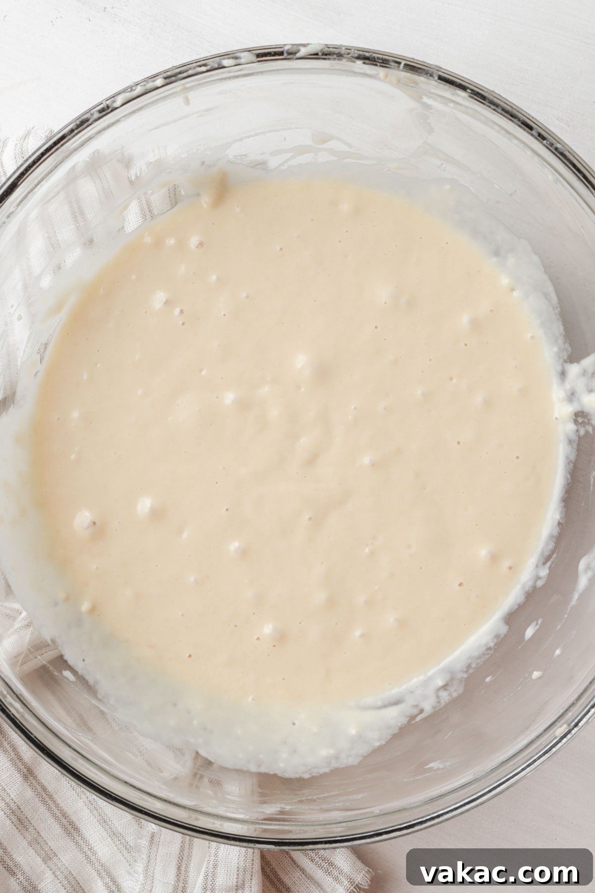 Overhead view of unproofed monkey bread dough in a glass mixing bowl, before its first rise.