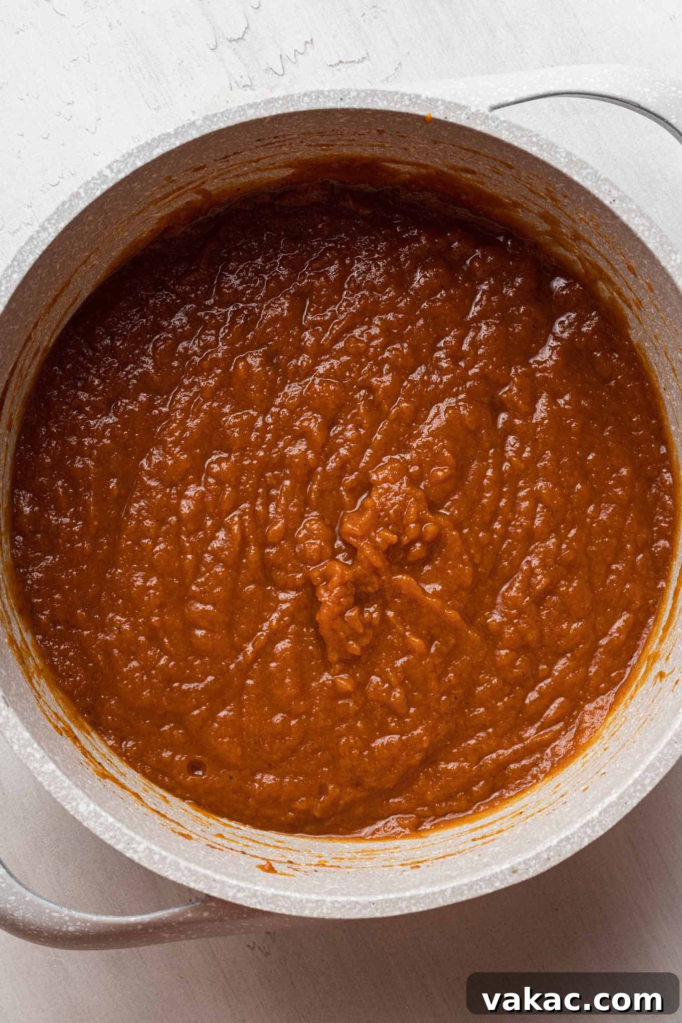 An overhead view of a saucepan filled with pumpkin butter mixture.