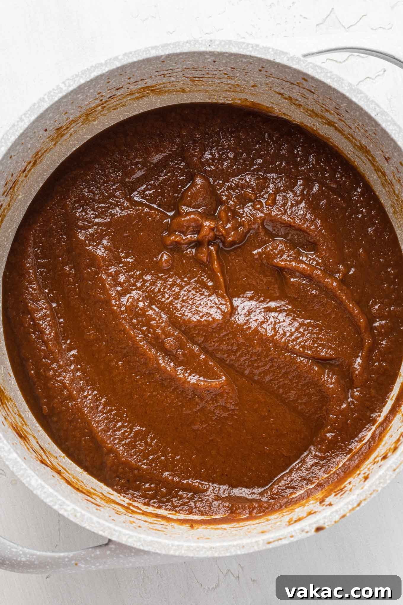 An overhead view of thickened pumpkin butter in a saucepan.