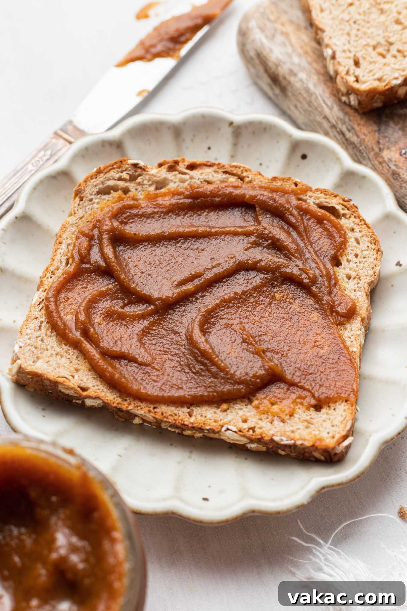 Golden Pumpkin Butter 5 A slice of toast slathered with pumpkin butter on a white plate.