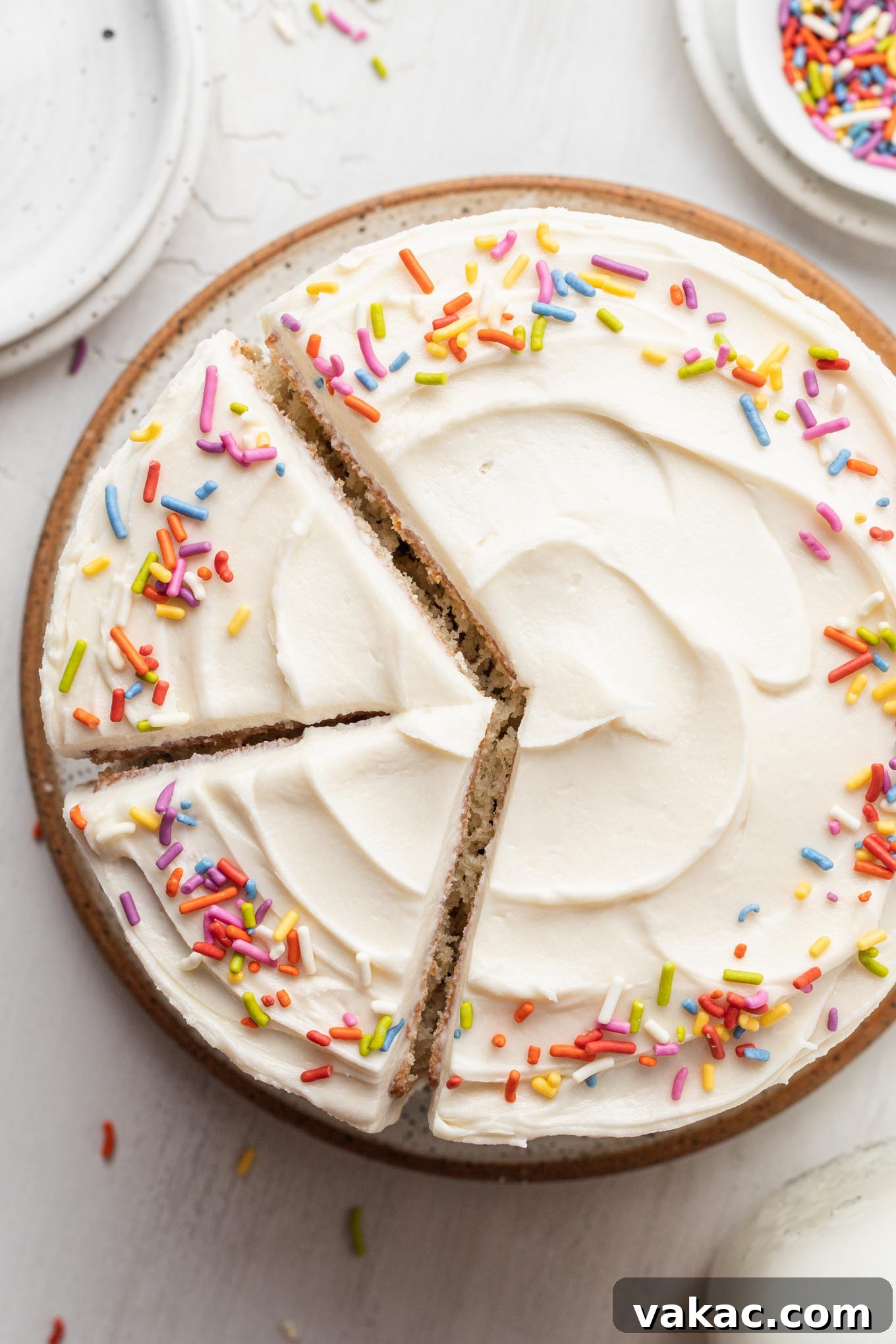 Petite Vanilla Perfection 8 An overhead view of a delicious 6-inch vanilla cake with two perfect slices cut out, revealing the layers inside.