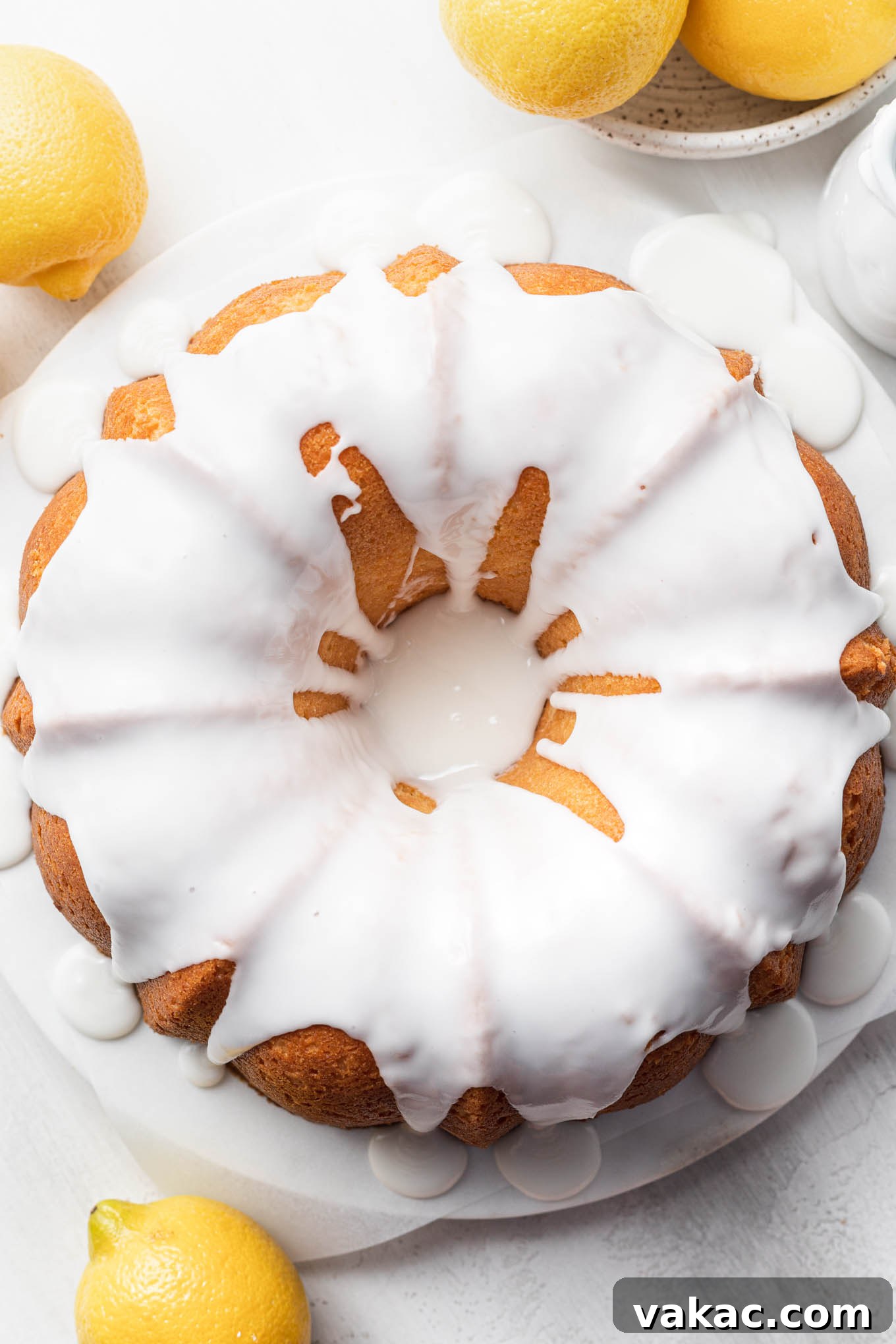 Sunshine Lemon Pound Cake 7 An overhead view of a lemon pound cake topped with glaze, surrounded by lemons.