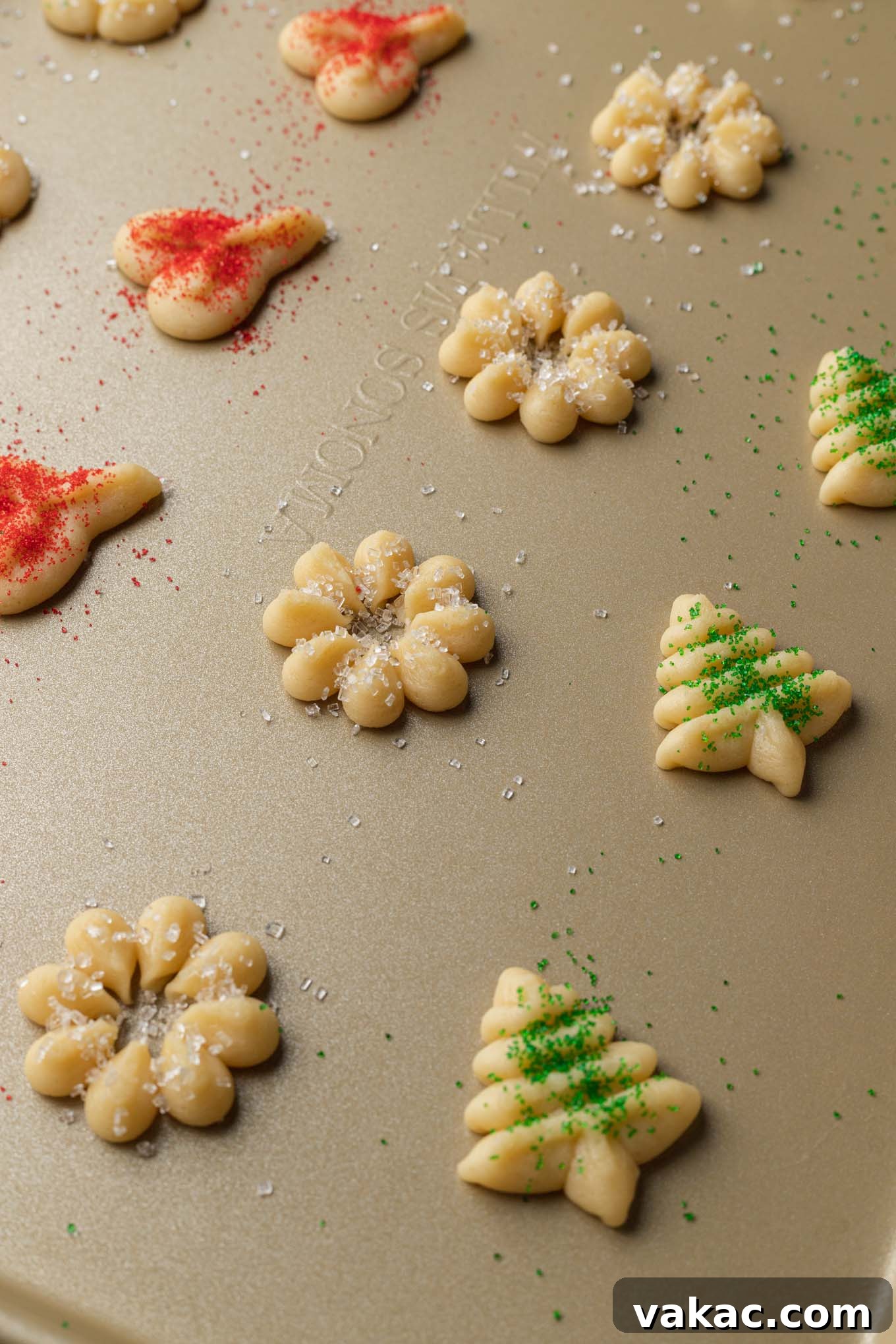 Buttery Spritz Cookies 6 Cooking dough pressed onto an ungreased baking sheet, showing intricate shapes.