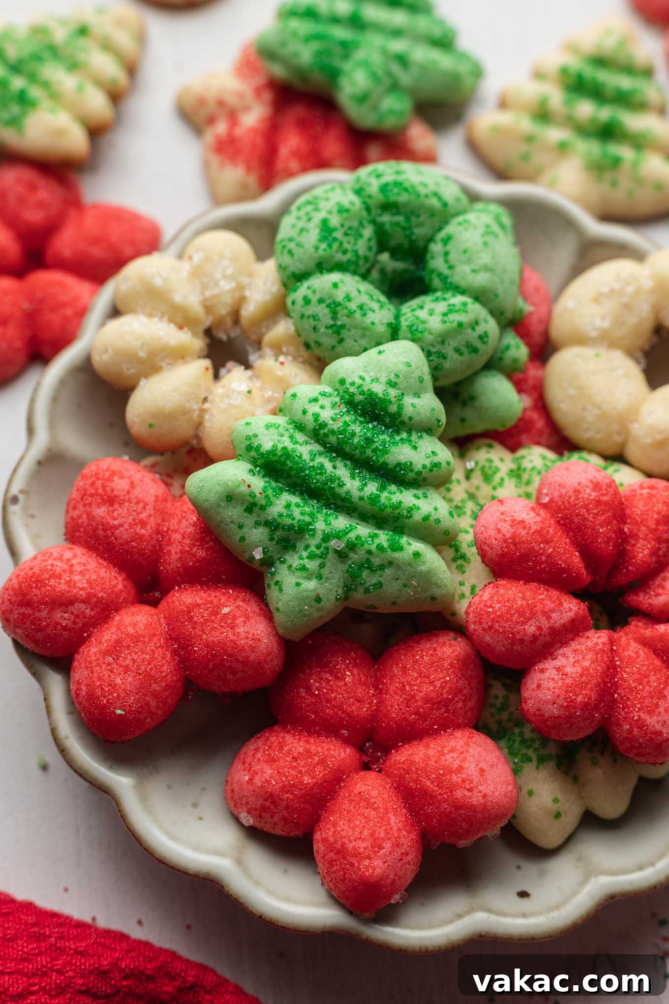 Buttery Spritz Cookies 8 A charming serving dish filled with perfectly baked butter spritz cookies, with additional cookies visible in the background.