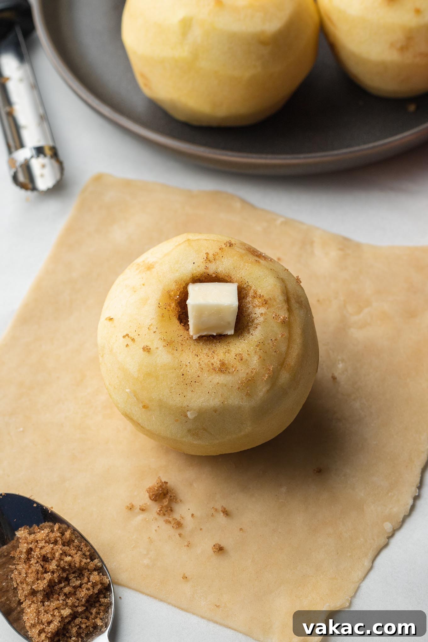 A peeled, cored apple stuffed with filling on a square of pie dough.