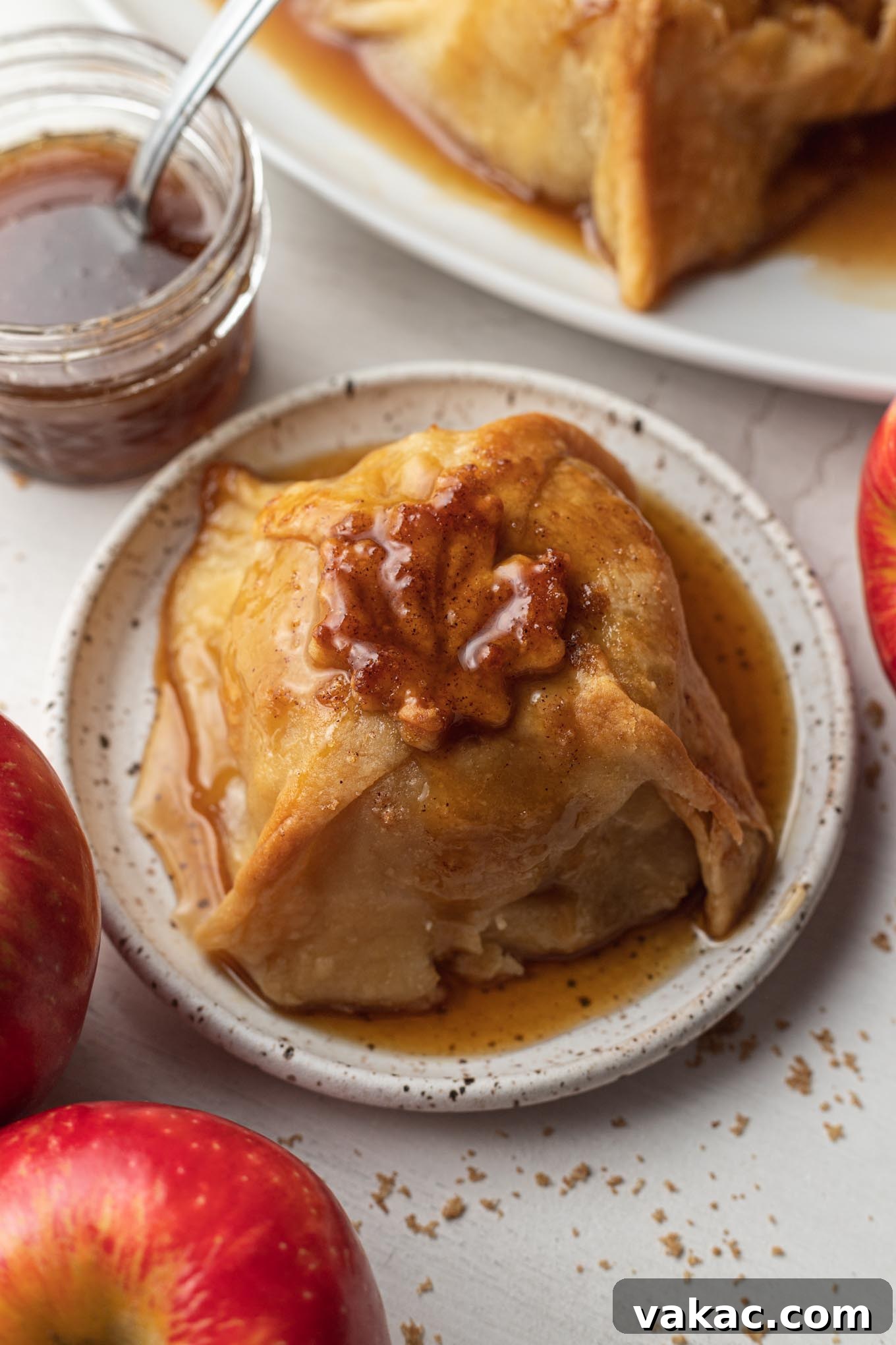 Golden Apple Delights 5 An apple dumpling with sauce on a dessert plate.