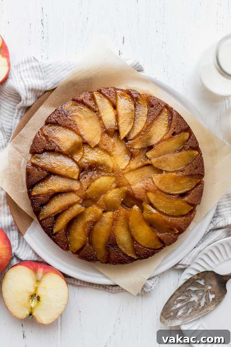 Caramel Apple Flip Cake 2 An overhead view of an apple upside-down cake with sliced apples and milk around it.