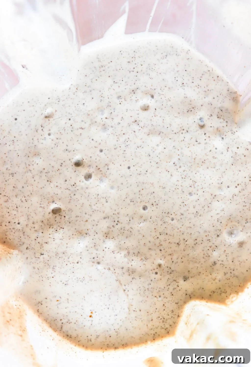 Dreamy Protein Tiramisu Chia Pudding with Yogurt 6 Close-up of bubbly, creamy batter with visible specks throughout, likely from whole grain or spices, in a mixing bowl. The mixture appears thick and airy.