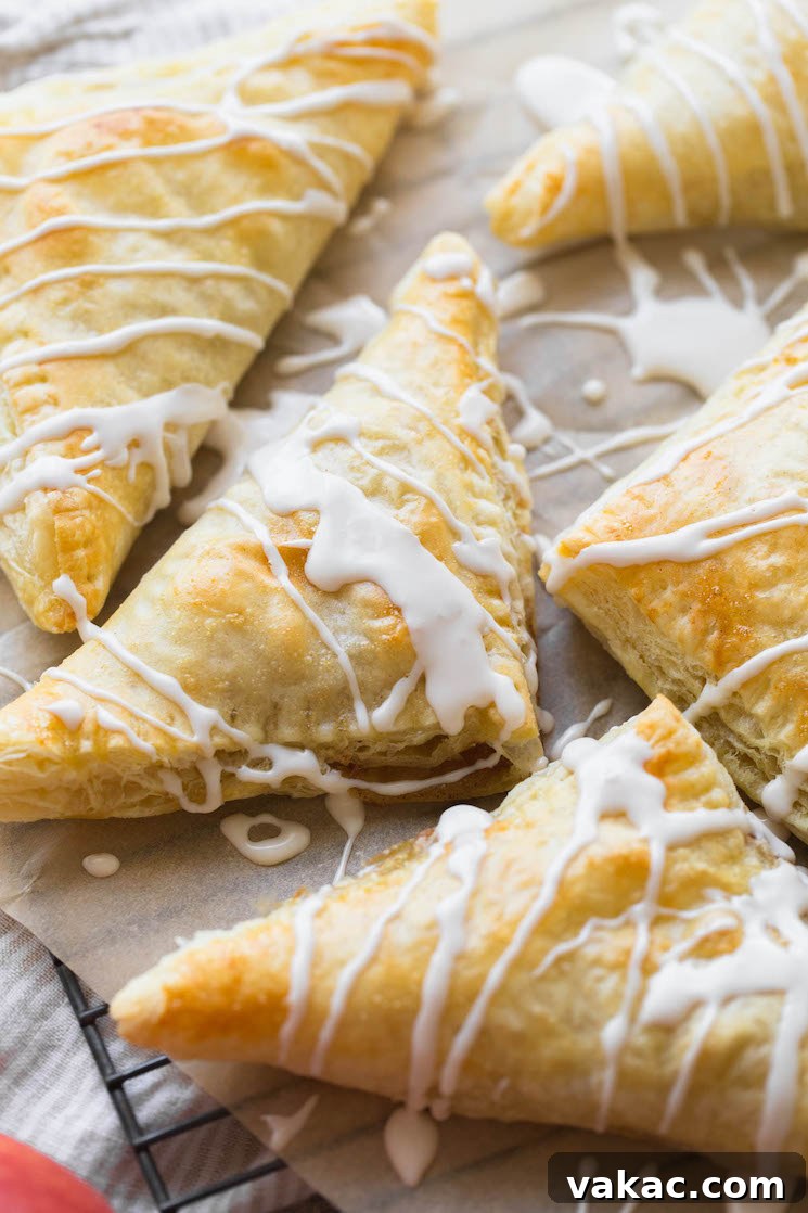 An up-close image of golden apple turnovers, glistening with a sweet maple cinnamon glaze.