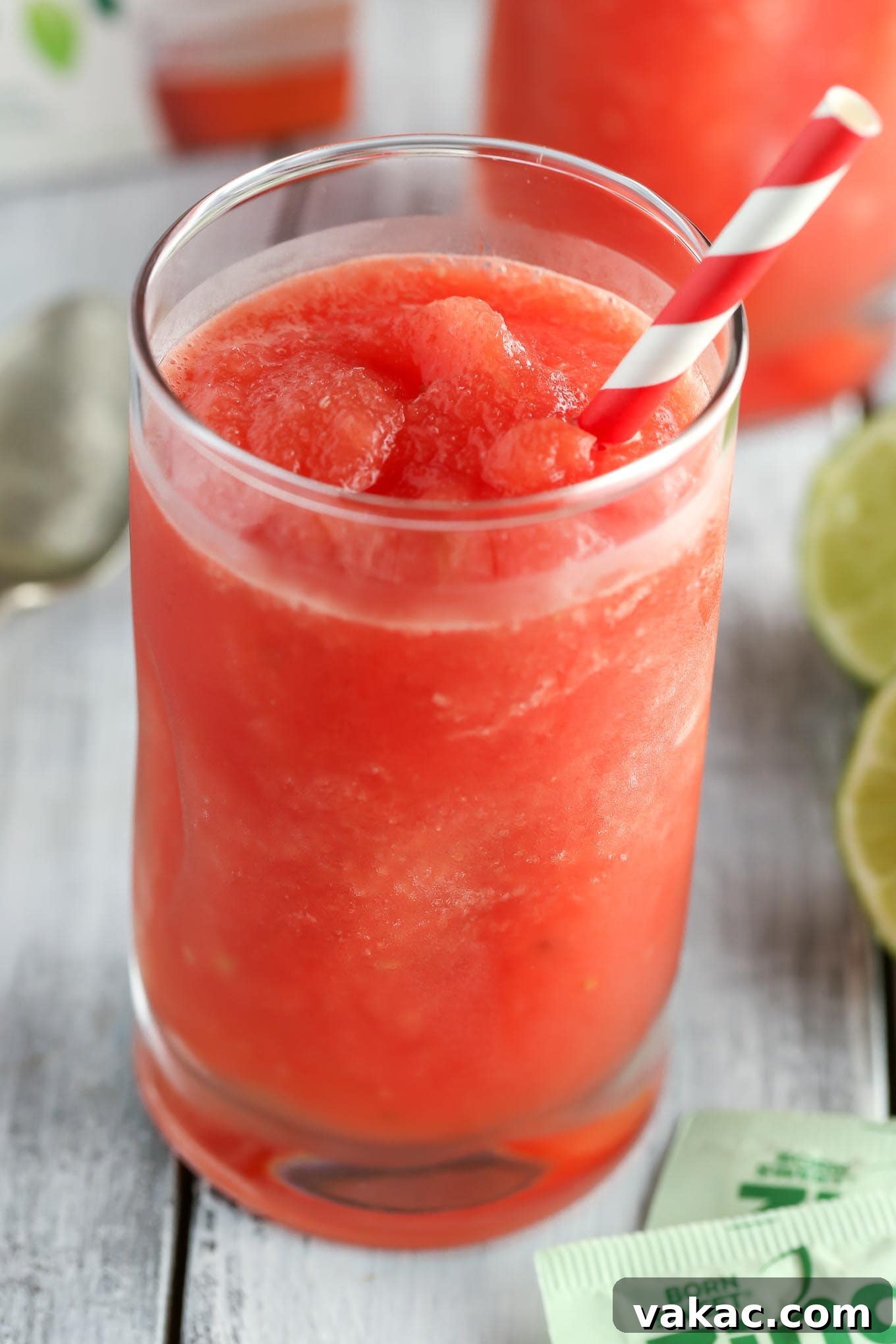Zesty Watermelon Freeze 5 A close-up of a glass of Watermelon Lime Slushie, showing its icy texture and the vibrant pink color, garnished with a lime wedge.