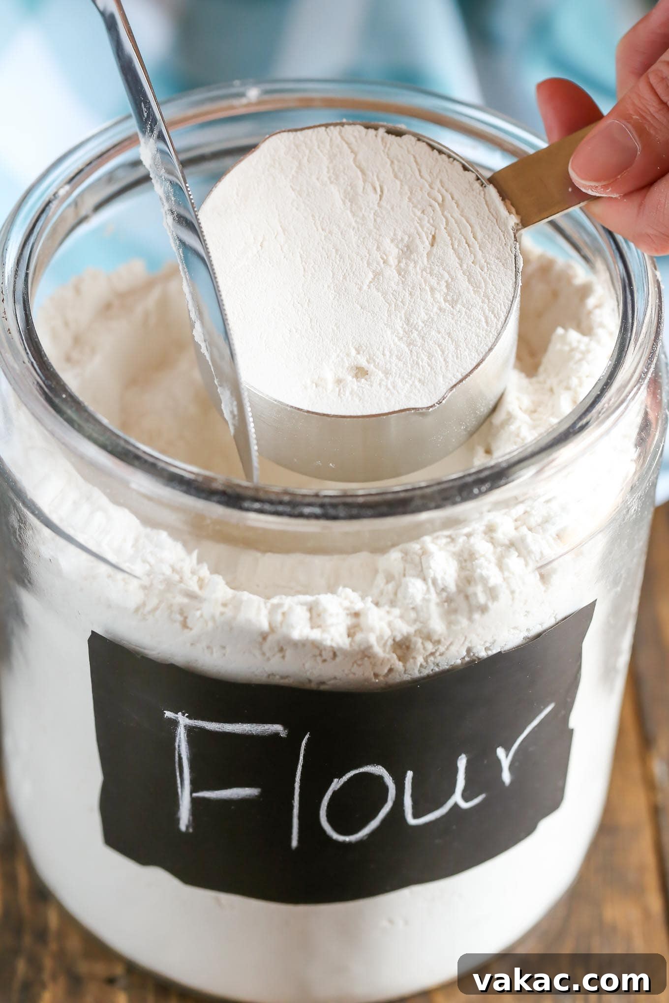 Leveling off the top of the flour with a straight edge for precise measurement