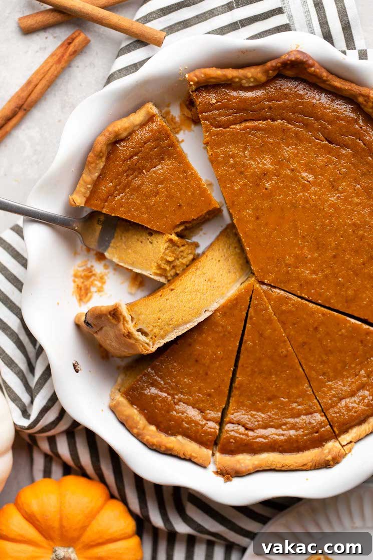 Autumn's Golden Slice 15 An overhead shot of a freshly baked pumpkin pie, sliced into perfect wedges, with cinnamon sticks and a small decorative pumpkin nearby.
