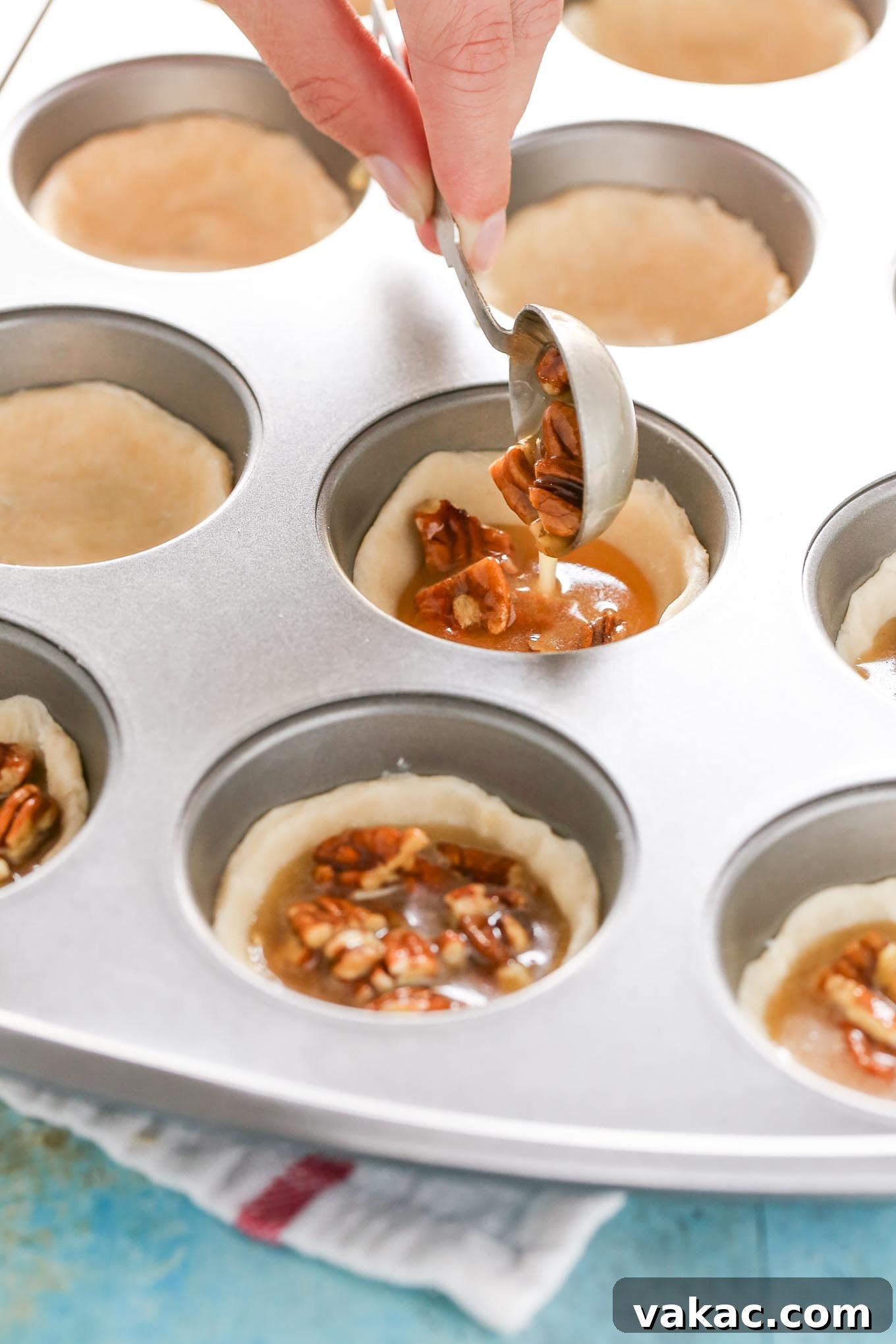 Tiny Pecan Treasures 3 Close-up of freshly baked mini pecan pies cooling in a muffin pan, showcasing their flaky crust and rich filling.
