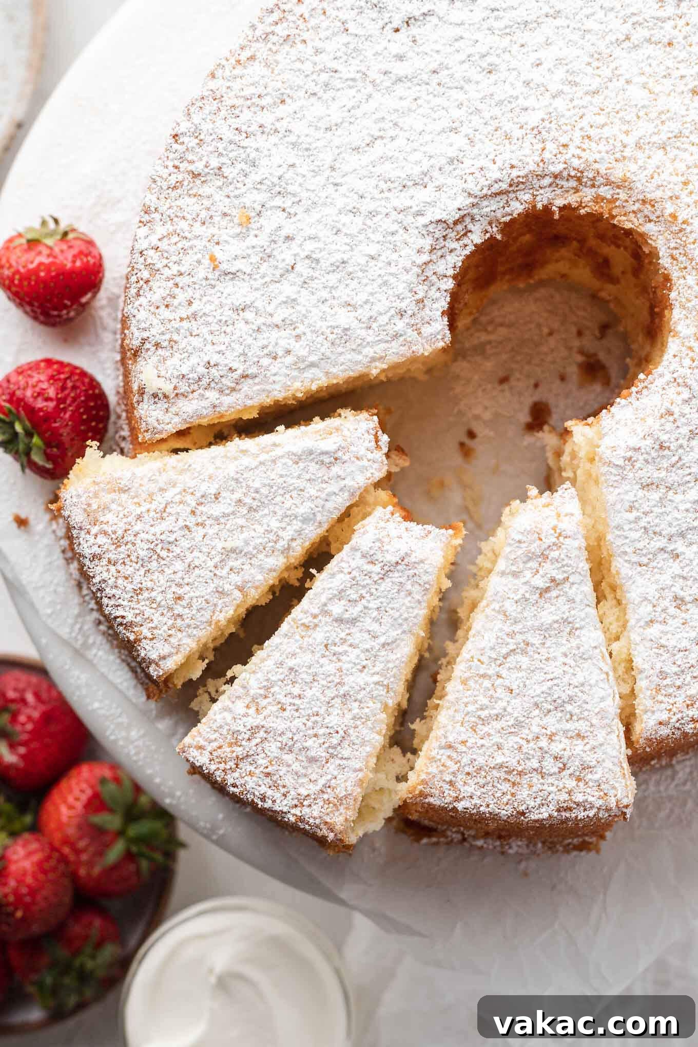 Overhead view of a vanilla chiffon cake, with three slices gracefully cut and ready to be served, highlighting its soft interior.