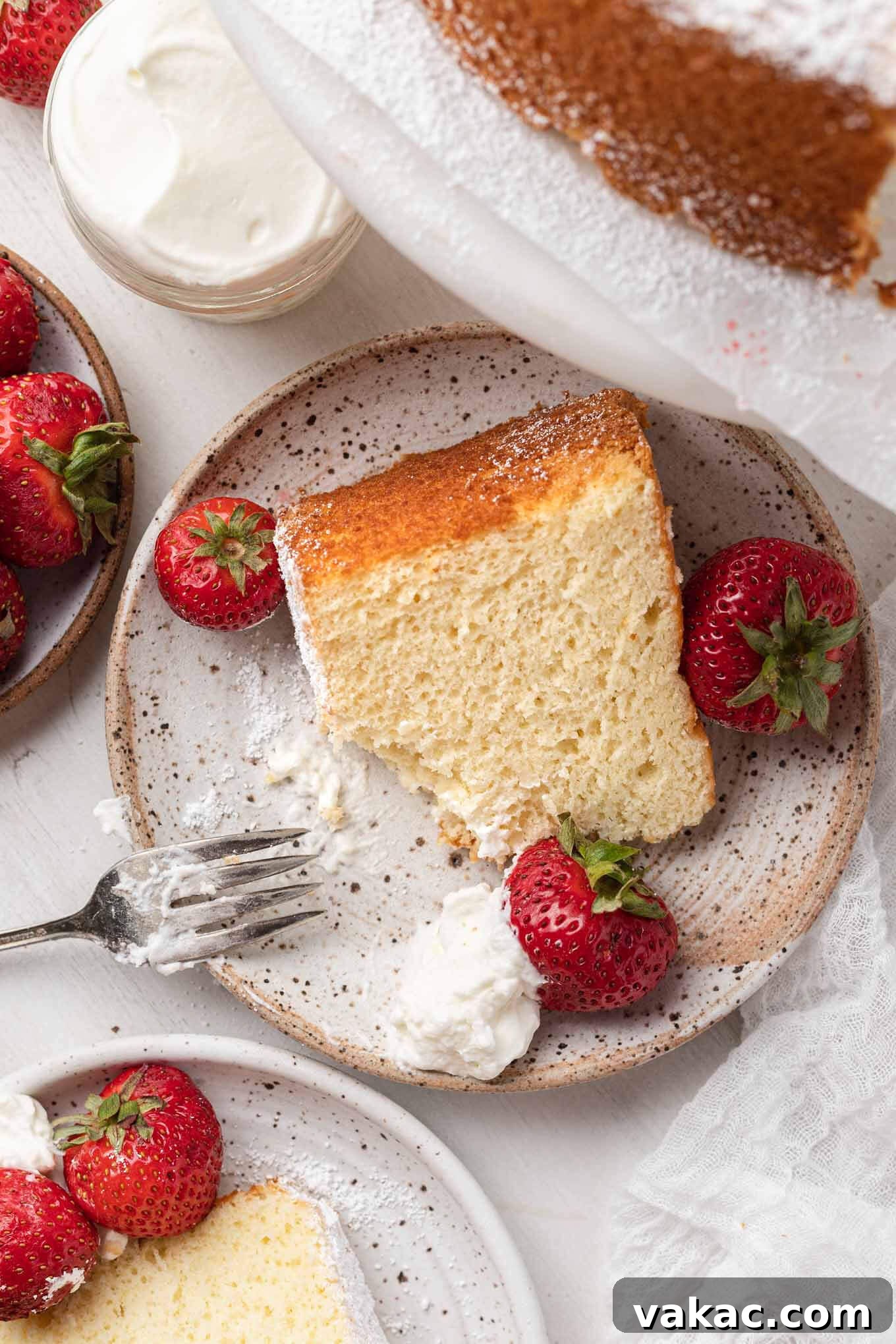 An overhead view of chiffon cake slices adorned with rich whipped cream and fresh, vibrant berries, ready to be enjoyed.