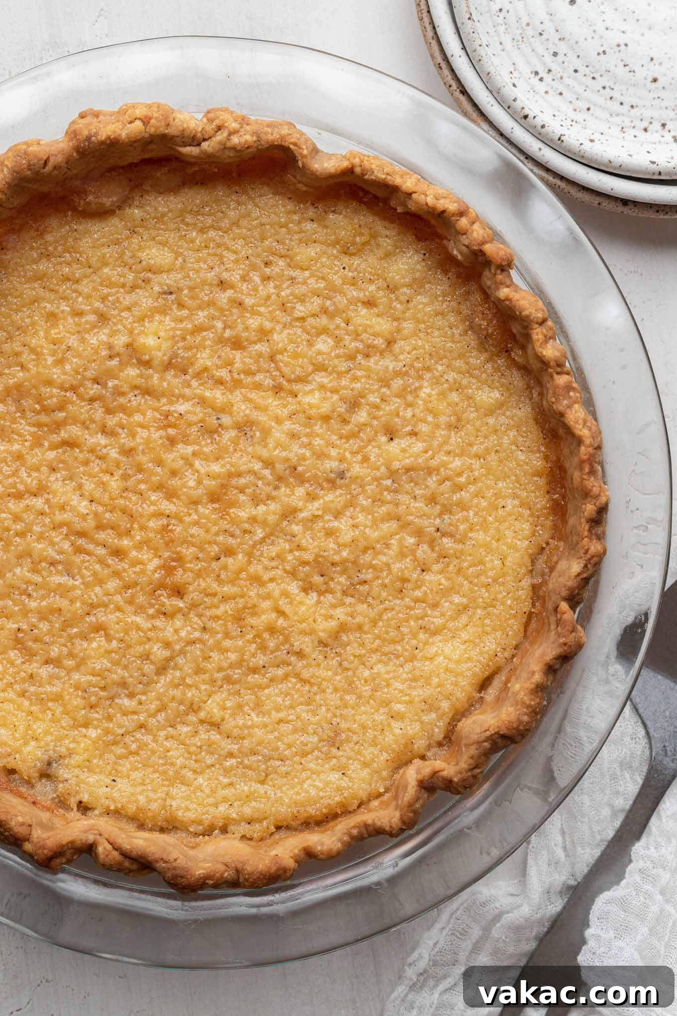 Southern Sunshine Pie 5 An inviting overhead view of a freshly baked Southern buttermilk pie, golden brown and perfectly set in a clear glass pie plate.