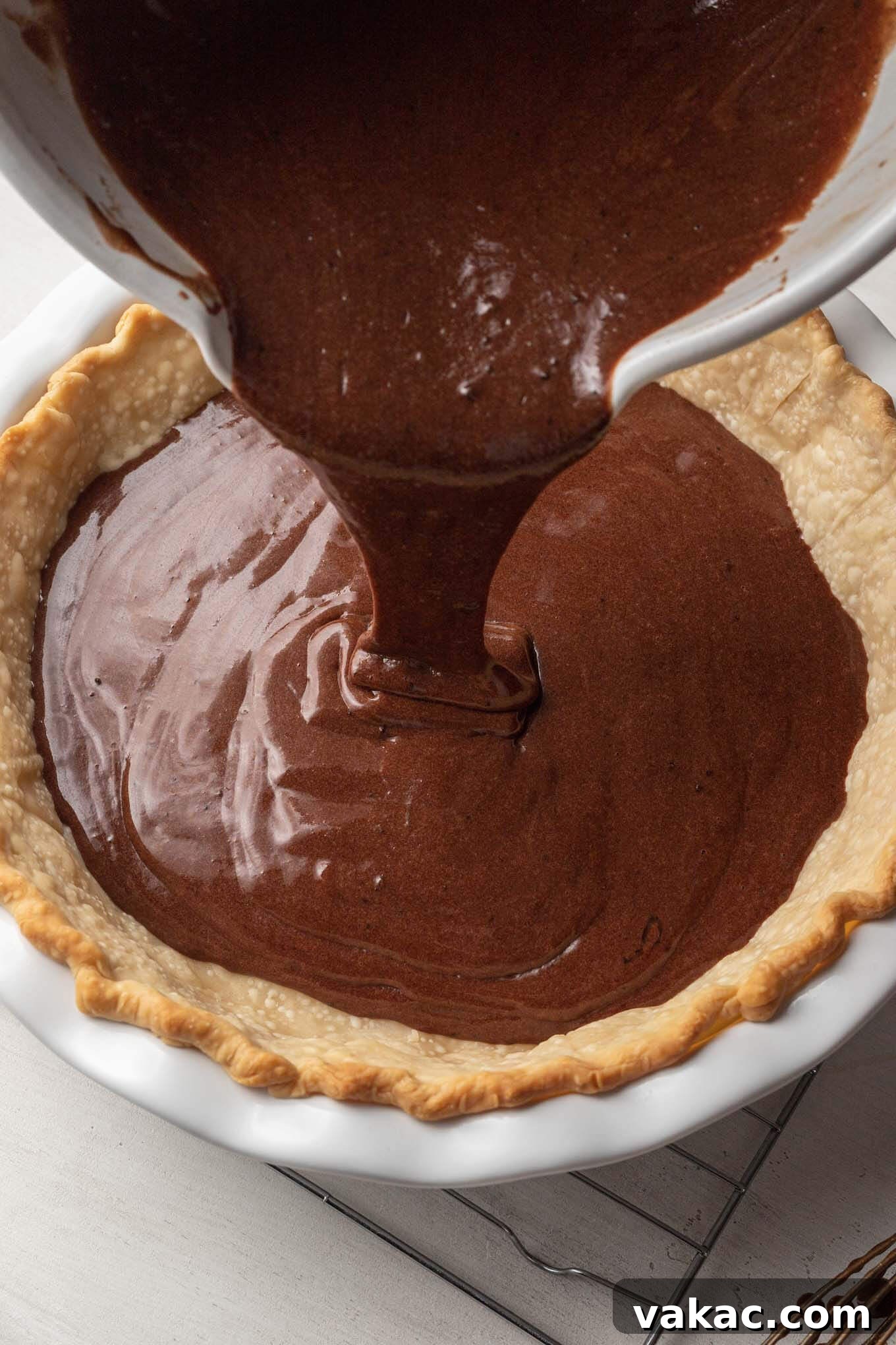 Decadent Chocolate Dream Pie 7 Chocolate chess pie filling being poured into a blind baked pie crust.