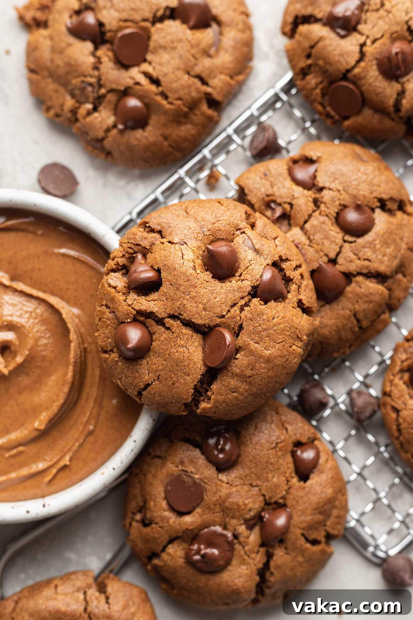 Irresistible Flourless Almond Butter Cookies 7 An overhead shot showcasing a platter of perfectly baked almond butter cookies, positioned beside an inviting bowl filled with creamy almond butter, highlighting the key ingredient.