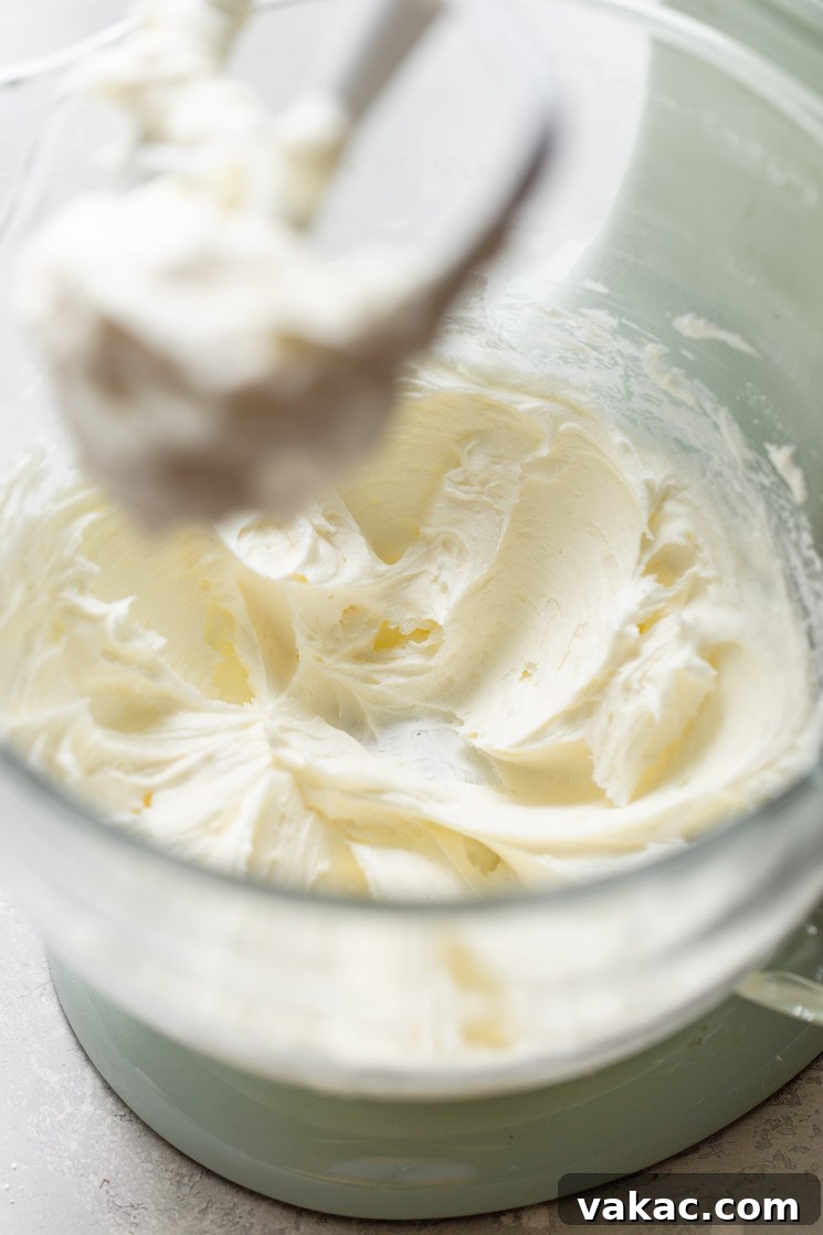A clear glass mixing bowl filled with softened unsalted butter, freshly creamed until smooth and light, ready for the next steps of making buttercream frosting.