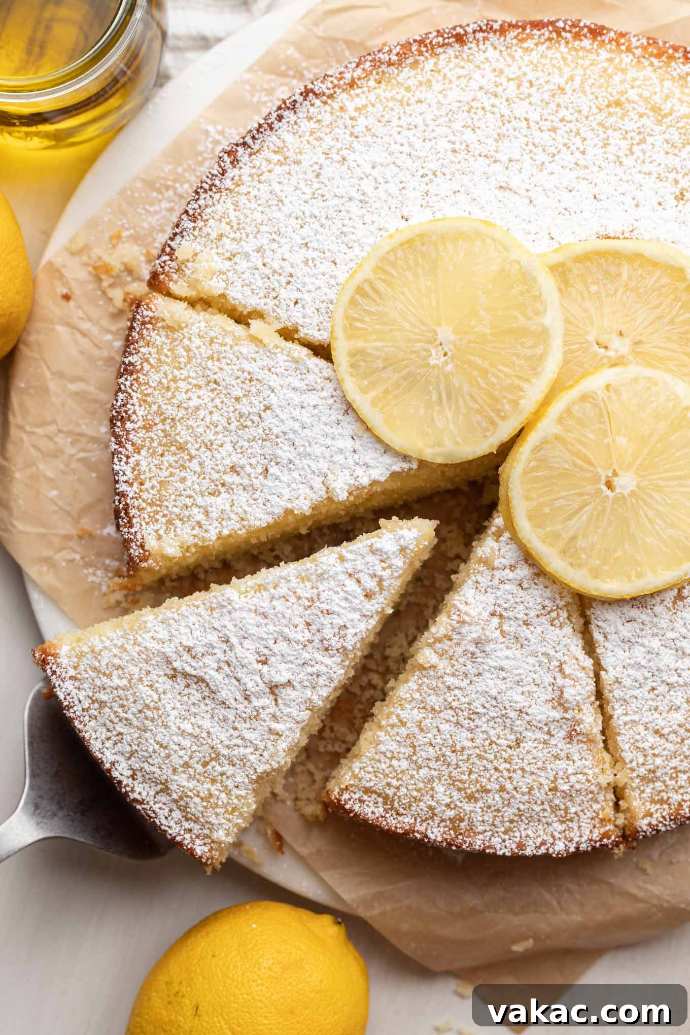 Sunshine Citrus Olive Oil Cake 6 An overhead shot of a freshly baked lemon olive oil cake, beautifully sliced and dusted with powdered sugar, ready to be served and enjoyed.