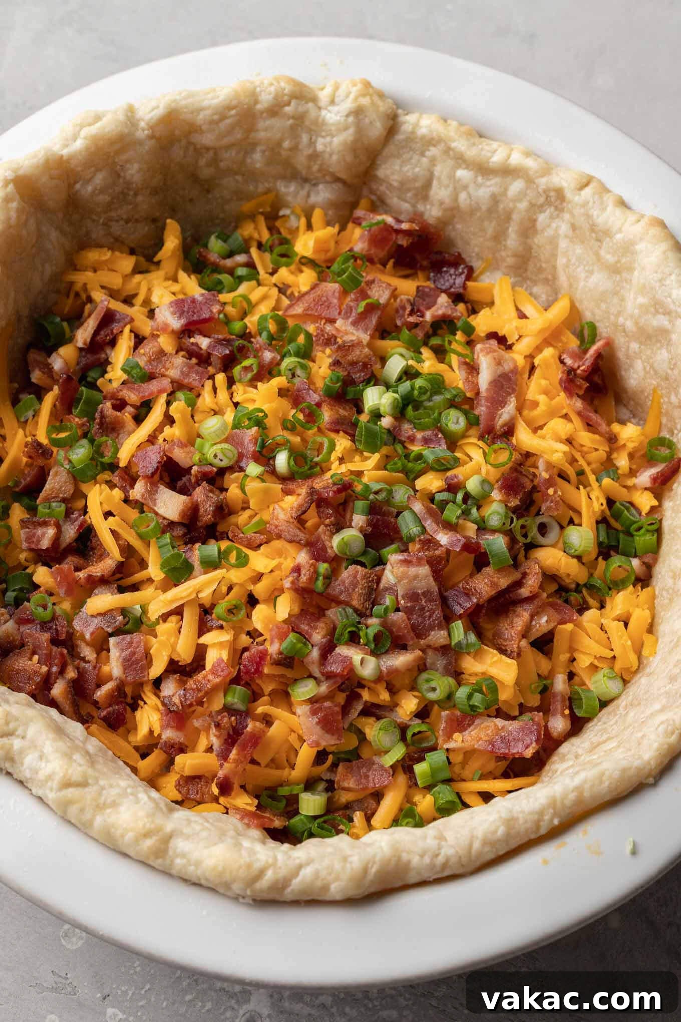 Quiche Made Simple 6 Bacon, chopped green onions, and shredded cheddar sprinkled over a blind baked pie crust.