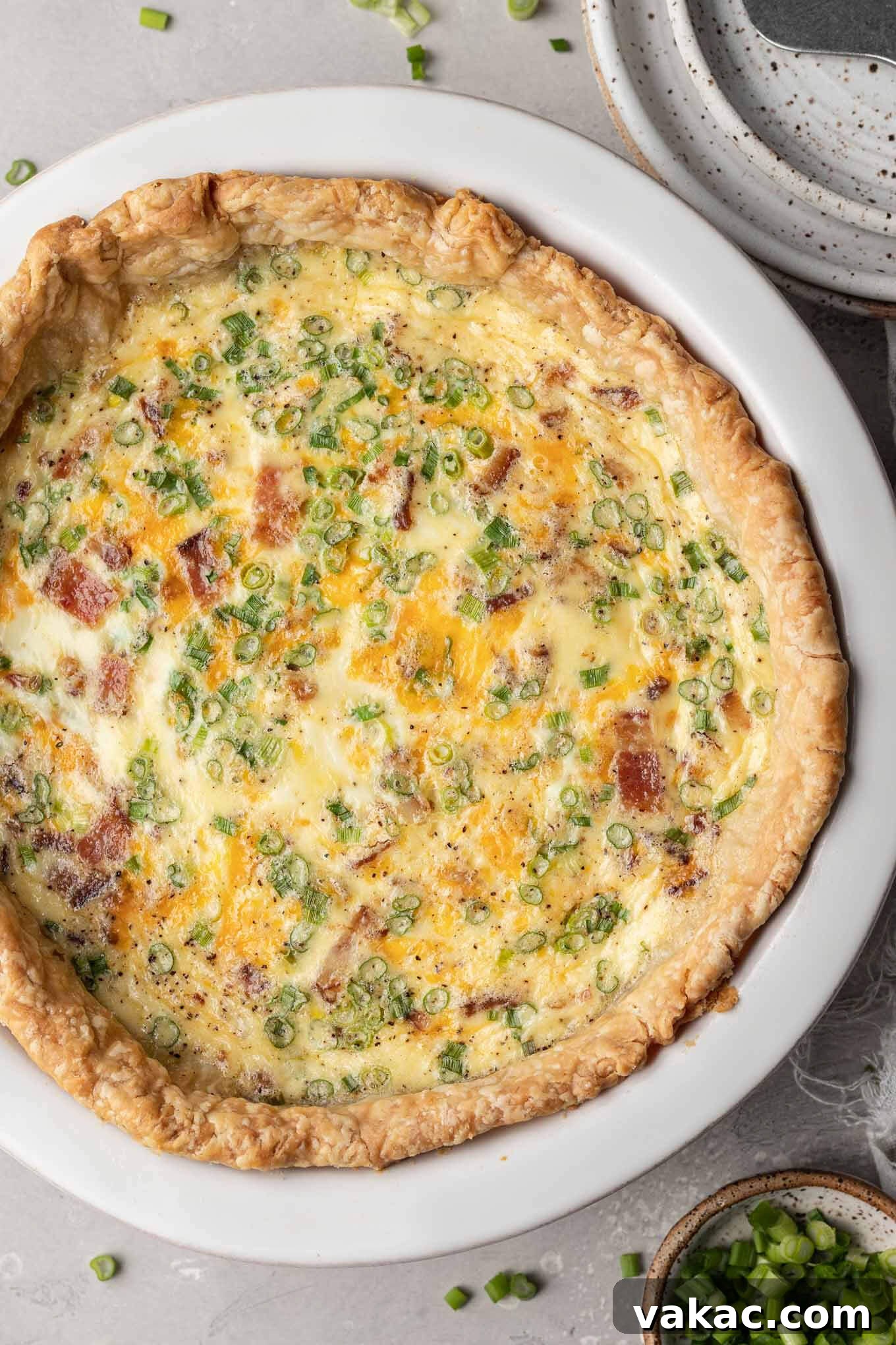 Quiche Made Simple 8 An overhead view of a baked bacon and cheese quiche in a white pie plate.