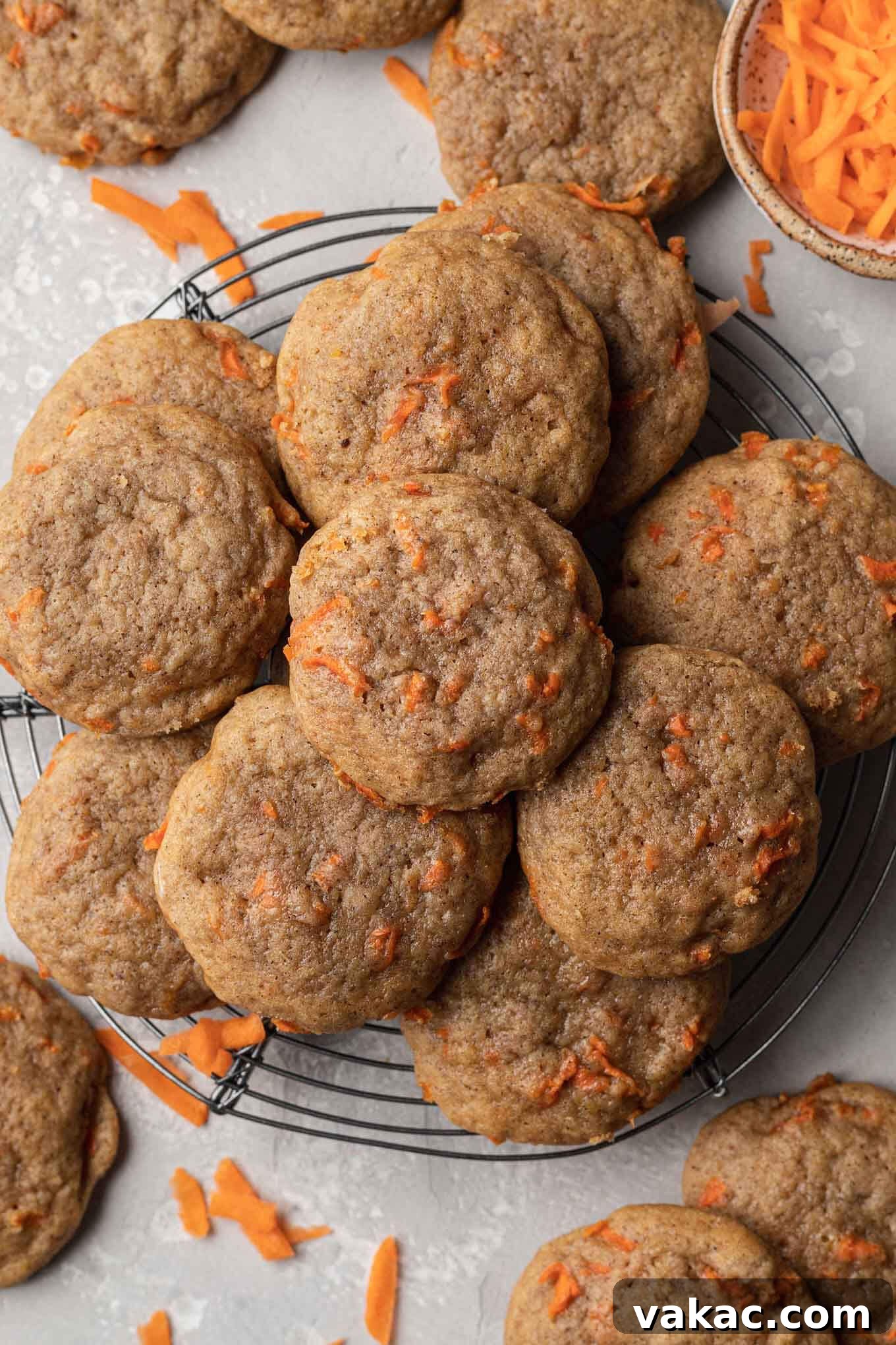 An overhead view of unfrosted carrot cookies on a wire cooling rack. 