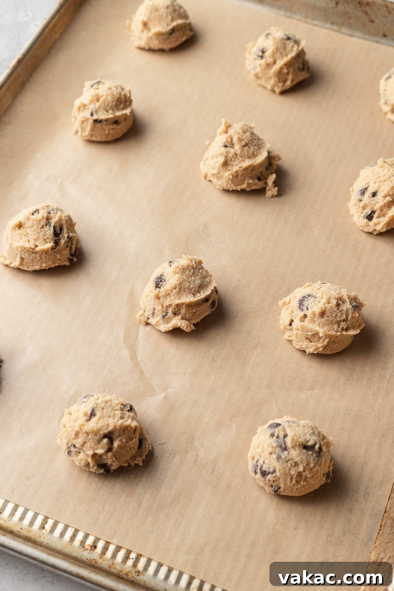 Egg-Free Chocolate Chip Bliss 6 Unbaked cookie dough balls lined up on a baking sheet.