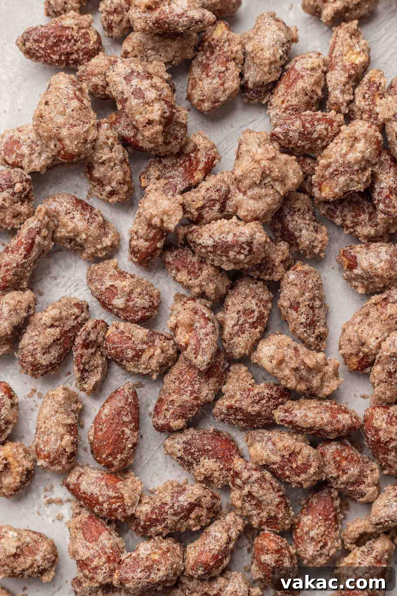 Sugar-Kissed Almonds 9 An overhead view of cinnamon sugar almonds on parchment paper.