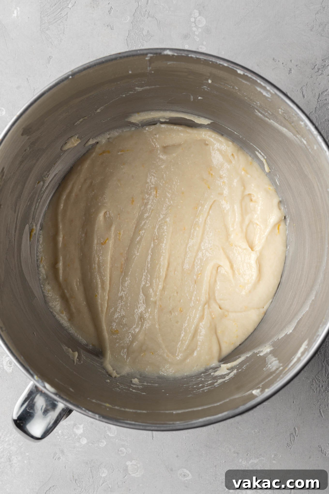 Sunshine Lemon Bliss Cupcakes 6 A mixing bowl filled with smooth, pale yellow lemon cupcake batter, perfectly combined and ready for baking.