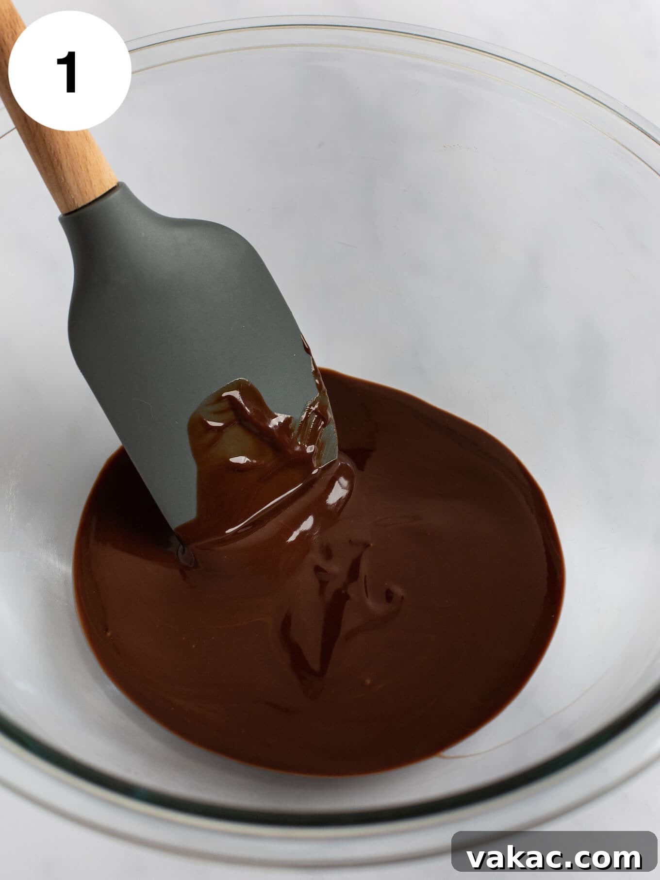 Decadent Molten Chocolate Lava Cake Perfection 4 Melted chocolate and butter mixed together in a glass mixing bowl with a rubber spatula.