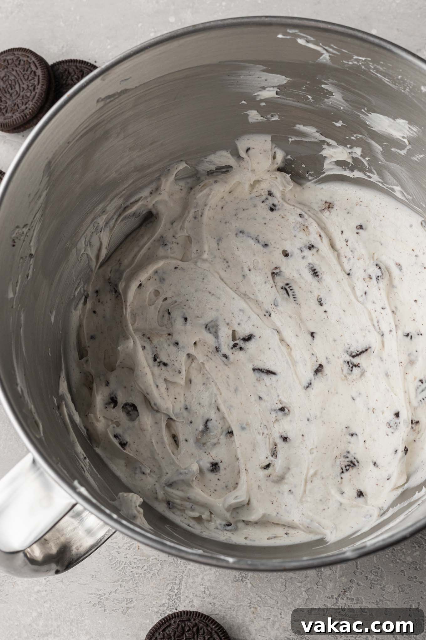 Irresistible Oreo Dream Pie 8 Oreo pie filling, featuring a creamy white base with visible chopped Oreo pieces, mixed together in the bowl of a stand mixer.