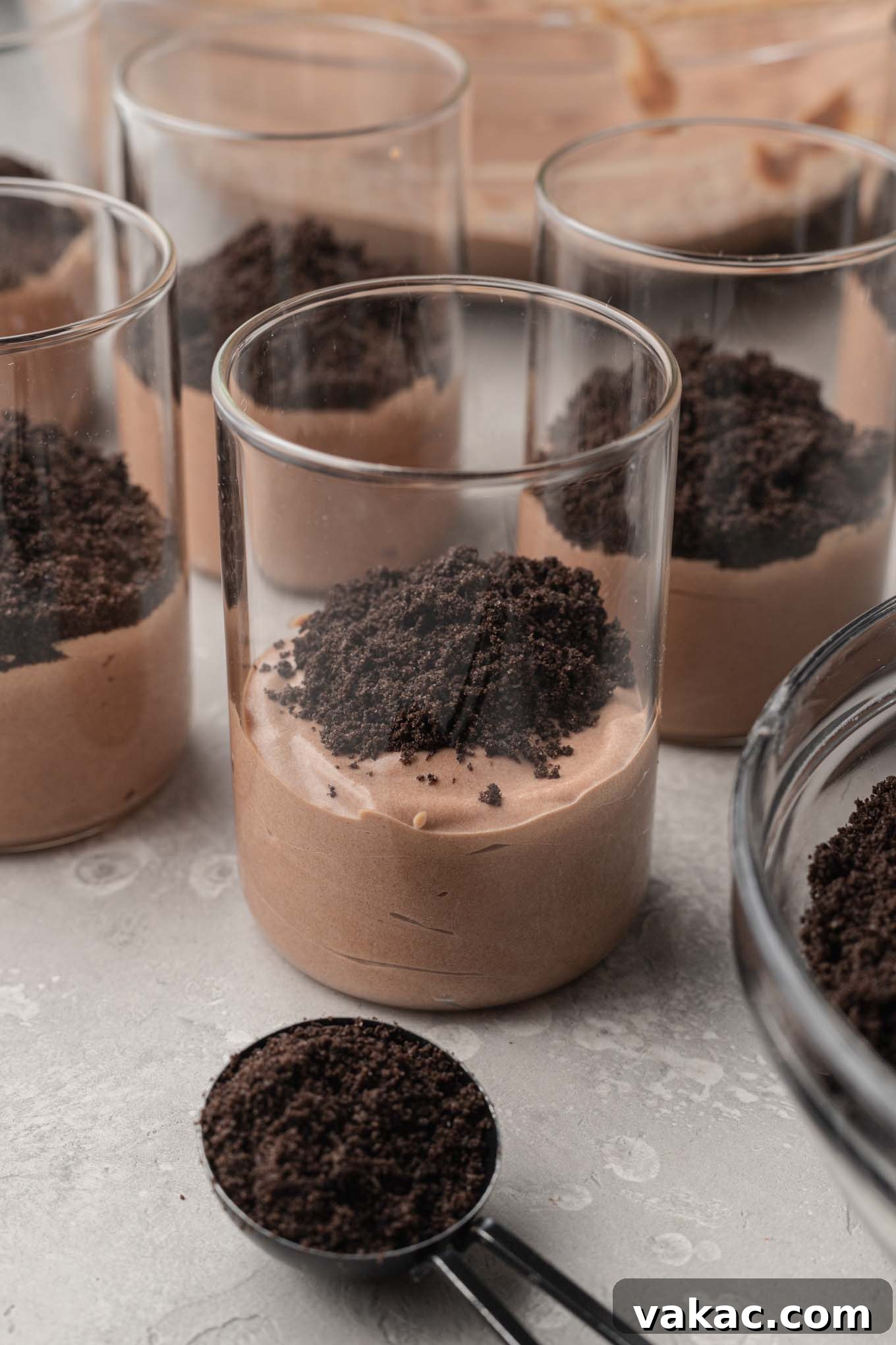 Sweet Soil Treats 8 A process shot showing the initial layers of homemade dirt pudding cups being assembled.