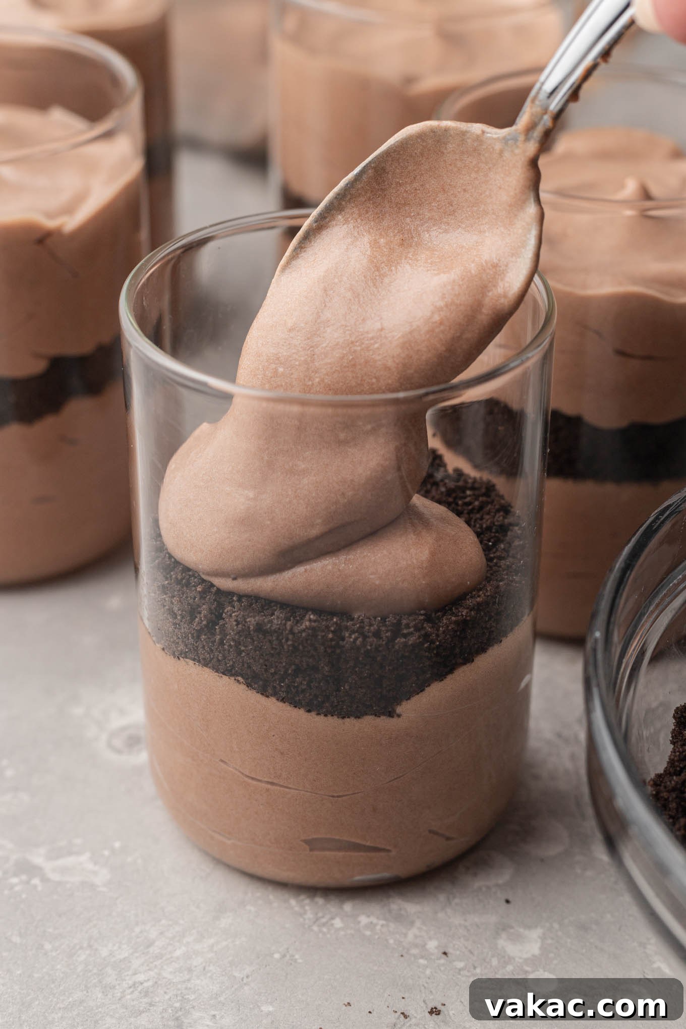 Sweet Soil Treats 9 A process shot showing fluffy chocolate pudding being spooned on top of a layer of Oreo crumbs.