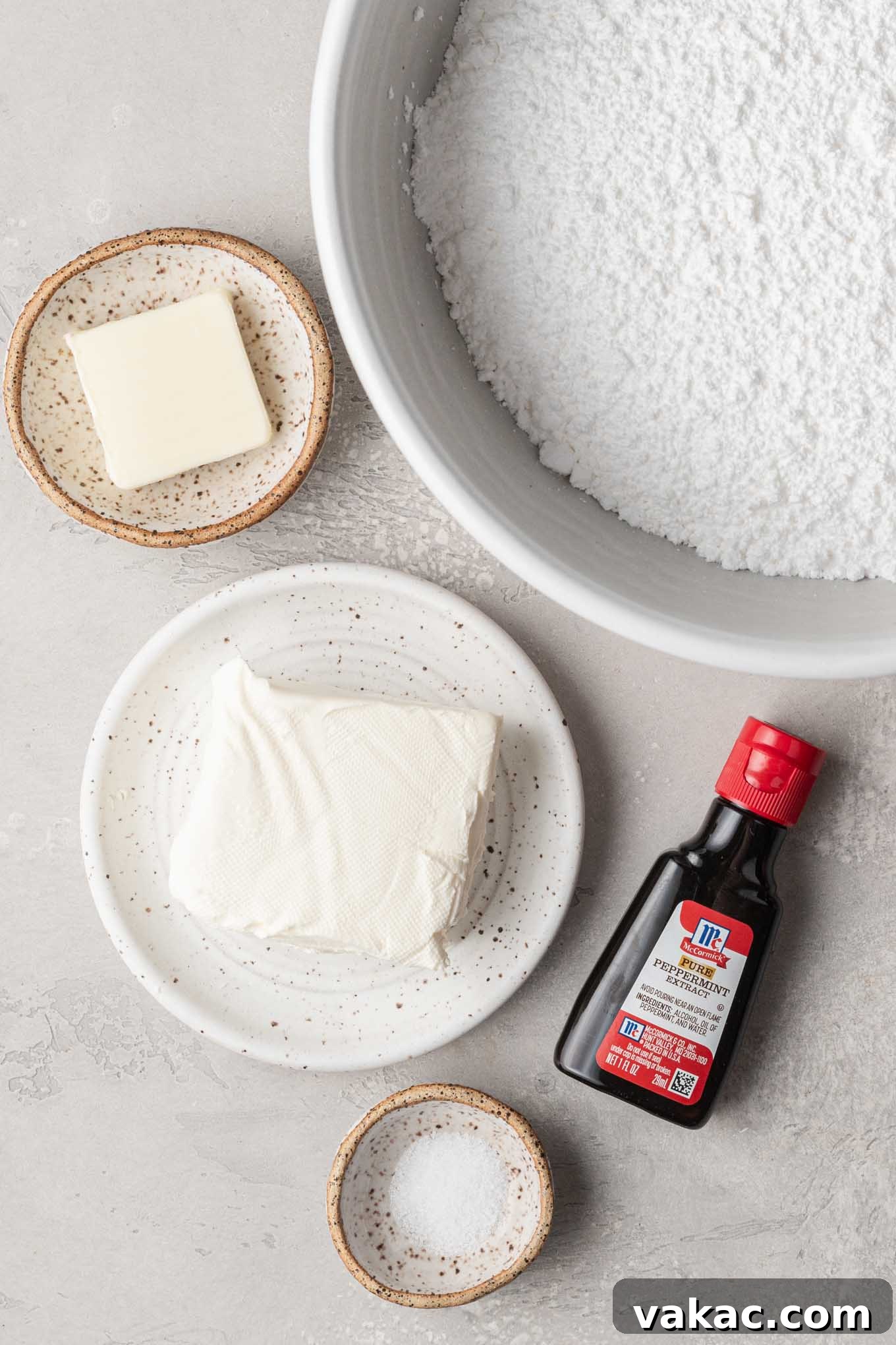 An overhead view of the essential ingredients laid out neatly for making delicious cream cheese wedding mints: cream cheese, butter, powdered sugar, peppermint extract, and a pinch of salt.