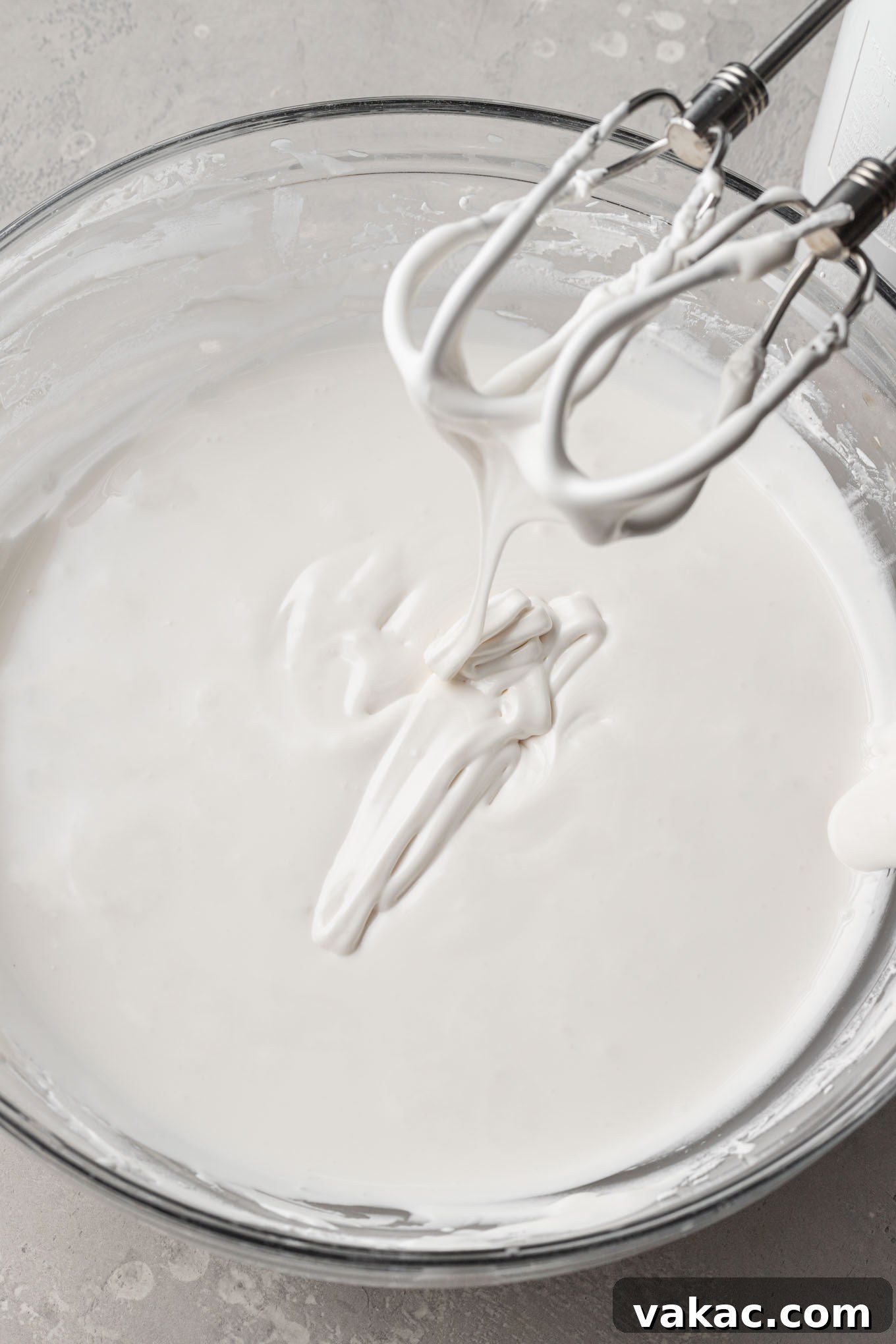 Royal icing that's been thinned to flood consistency in a mixing bowl.
