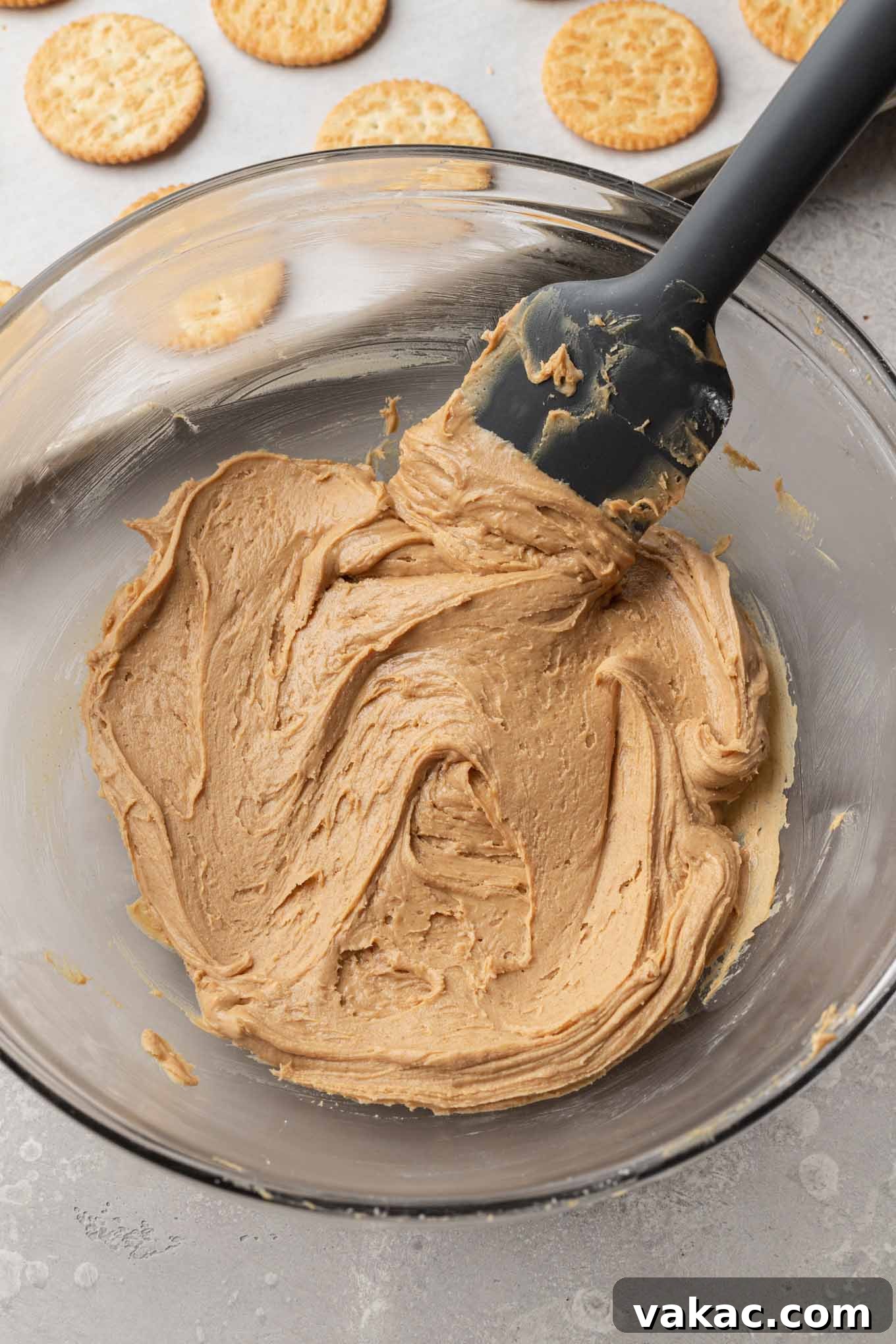 Golden Ritz Delights 4 An overhead view of creamy peanut butter and powdered sugar being mixed together in a glass mixing bowl, forming the delicious cookie filling.