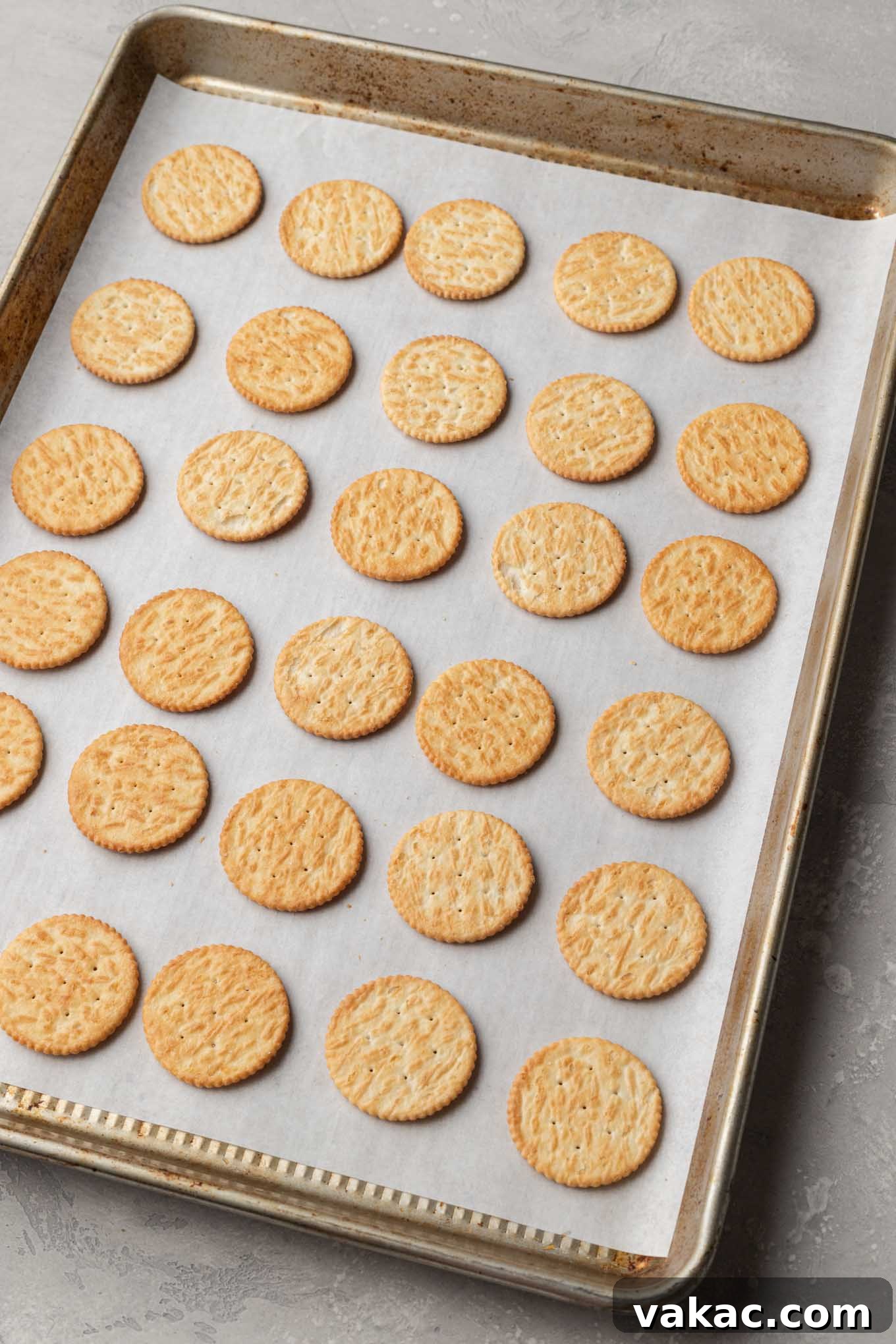 Golden Ritz Delights 5 An overhead view of 30 Ritz crackers neatly lined up in rows on a baking sheet, ready for the peanut butter filling.