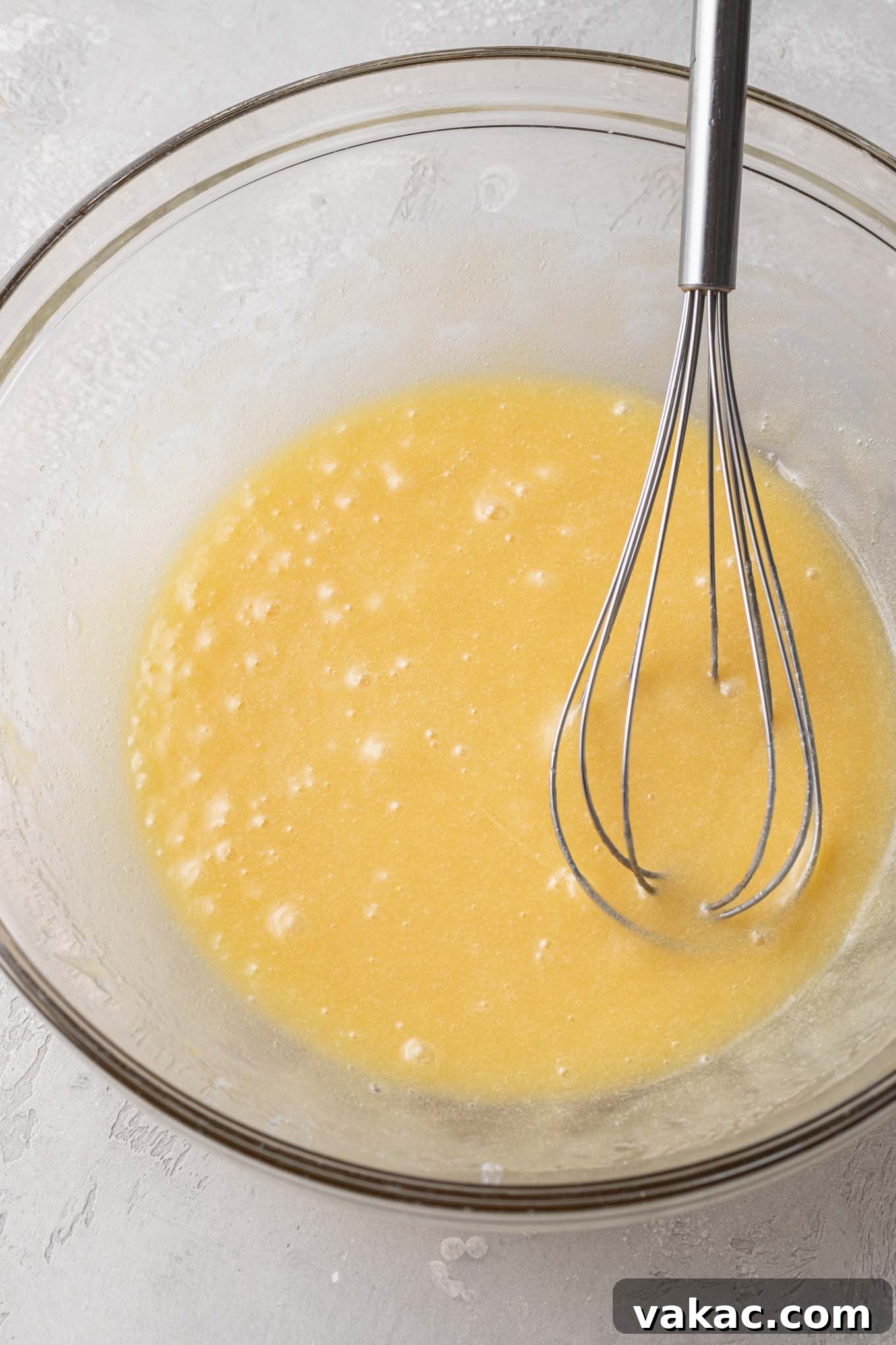 Bite-Sized Brownie Bliss 5 An overhead view of melted butter, eggs, and sugar in a glass mixing bowl with a whisk.