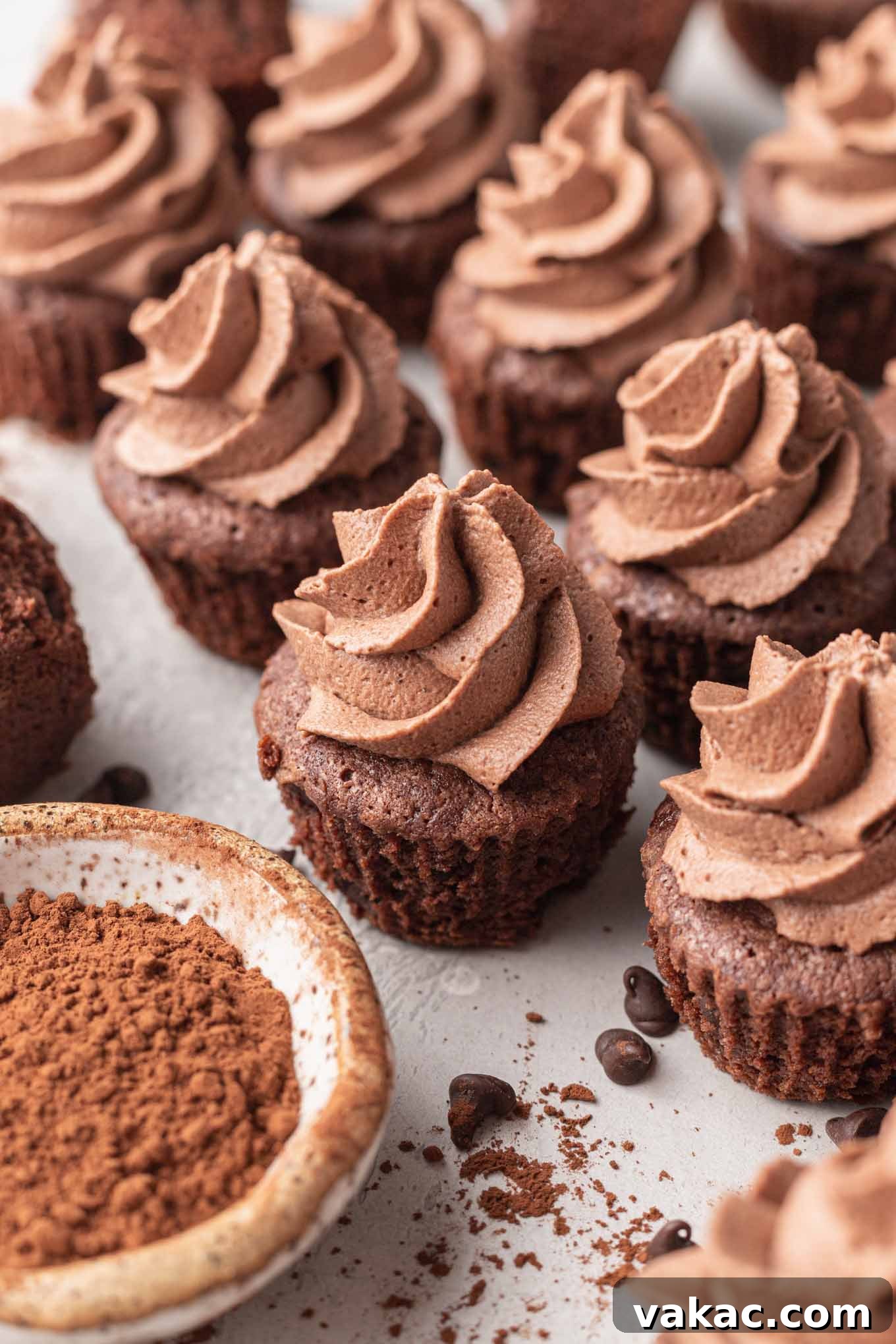 Bite-Sized Brownie Bliss 8 Mini brownies topped with chocolate whipped cream, next to a bowl of cocoa powder.