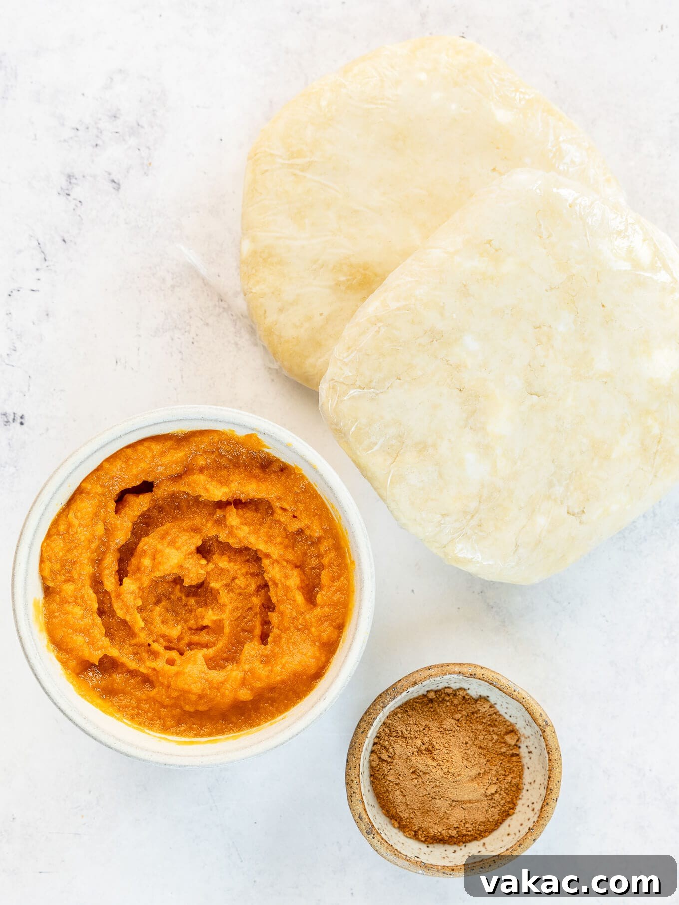 Autumn Pumpkin Pockets 3 An overhead view showcasing essential ingredients: creamy pumpkin puree, aromatic pumpkin pie spice, and ready-to-roll pie dough.