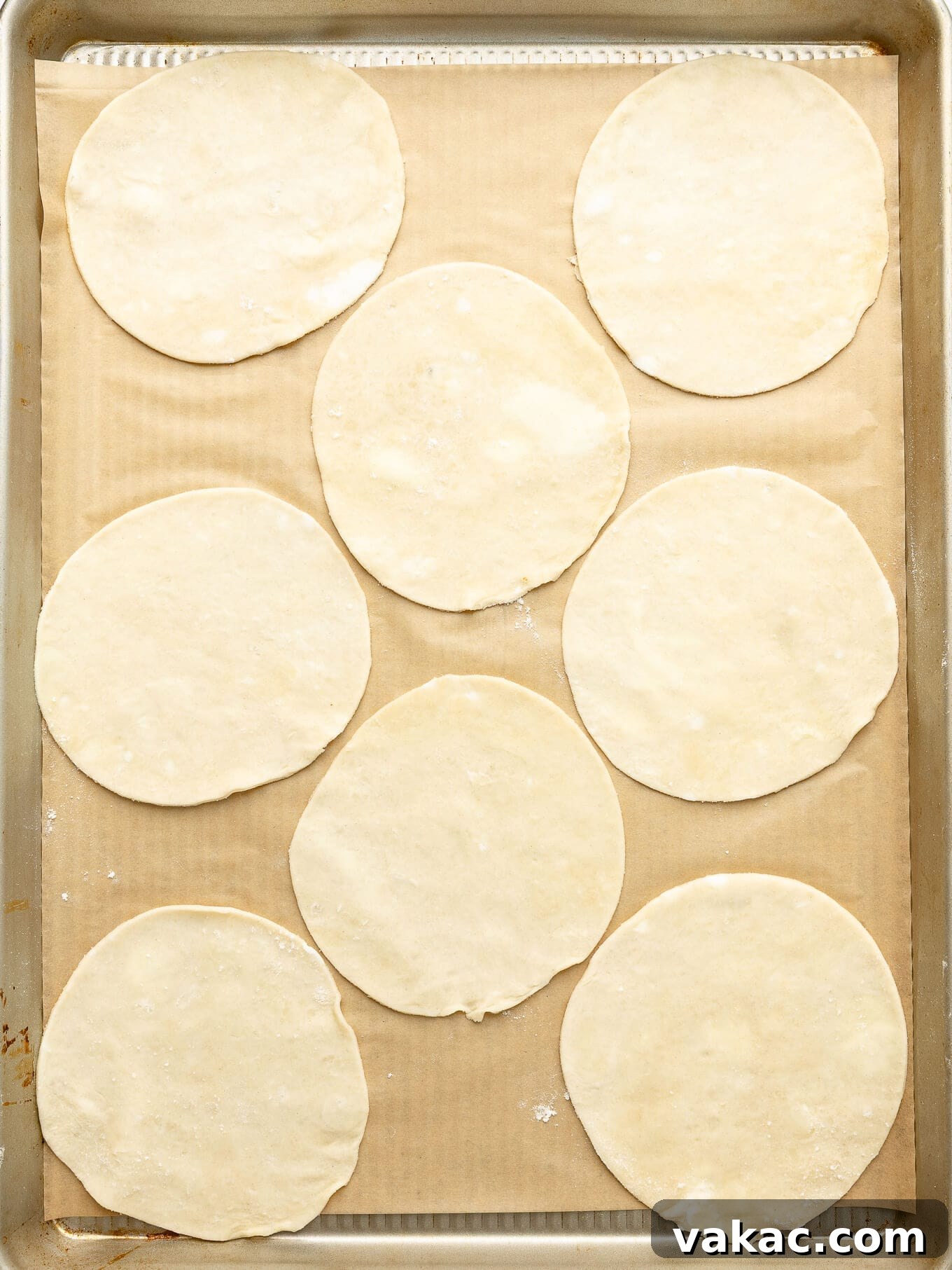 Autumn Pumpkin Pockets 5 Perfectly cut circles of pie dough arranged neatly on a parchment-lined baking sheet, ready for filling.