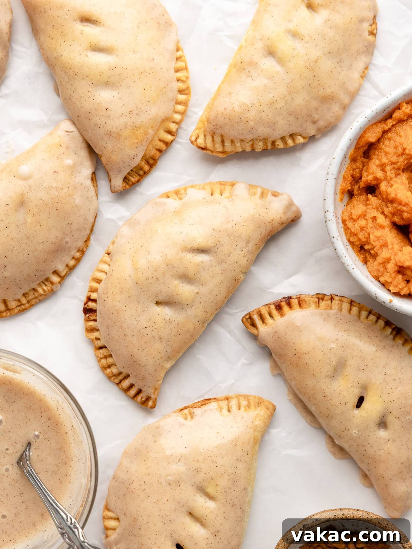 Autumn Pumpkin Pockets 10 An inviting overhead view of glazed pumpkin hand pies, their sweet icing glistening, arranged beautifully for serving.