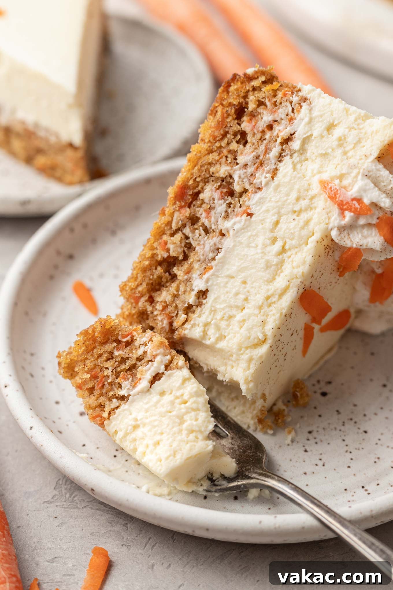 Decadent Spiced Carrot Cheesecake 11 A slice of carrot cake cheesecake on a dessert plate with a fork.