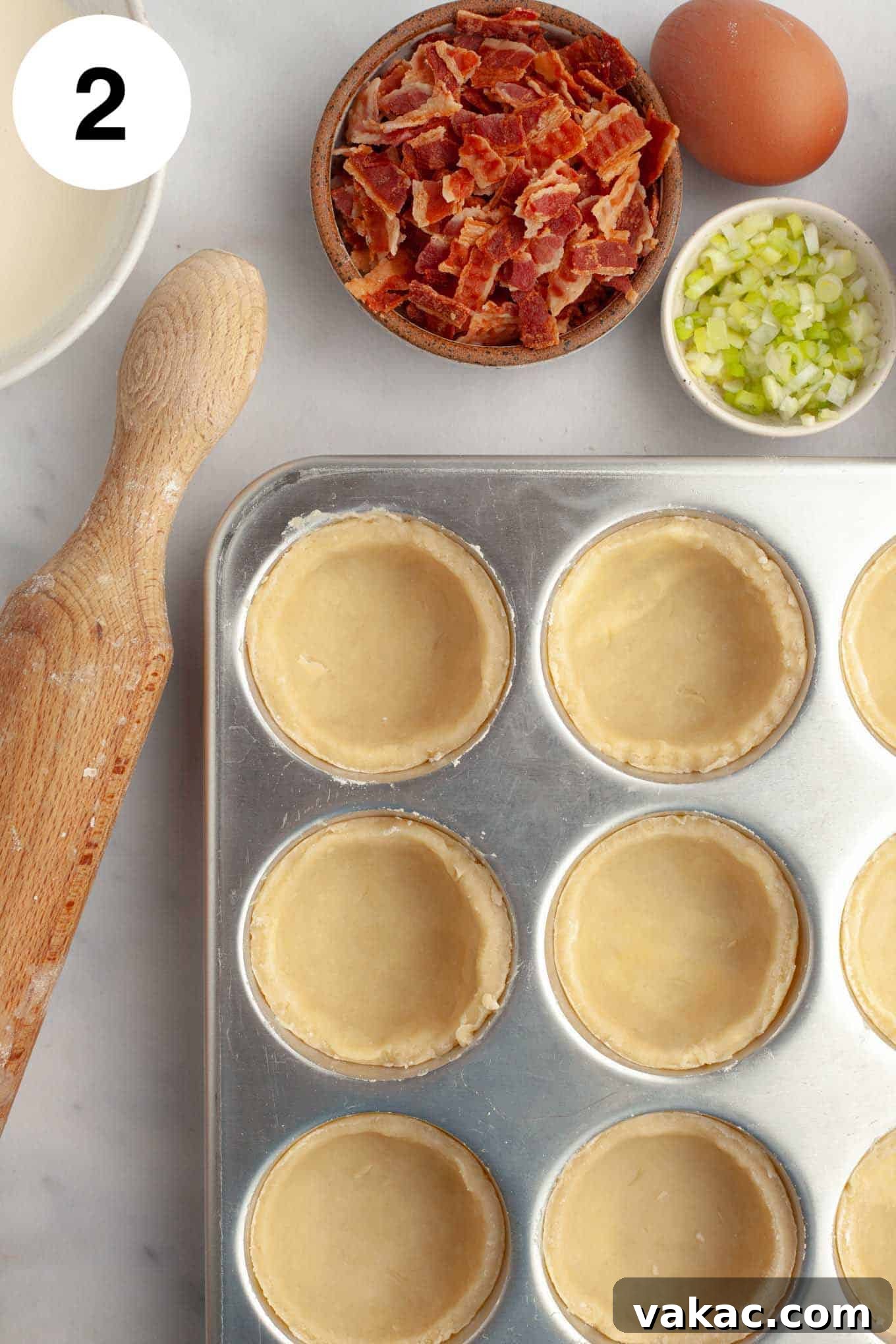 Bite-Sized Quiche Delights 5 An overhead view of mini quiche crusts meticulously pressed into the individual cups of a muffin pan, awaiting their savory filling.