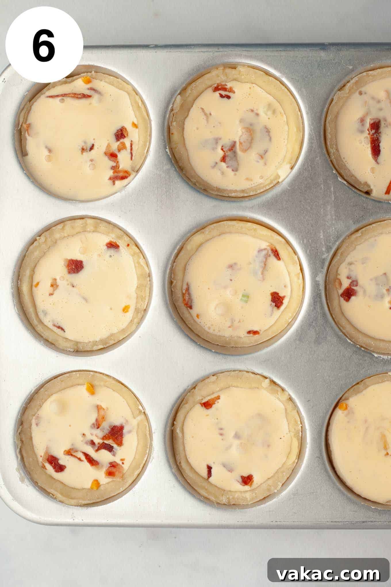 Bite-Sized Quiche Delights 9 An overhead view of all unbaked, filled mini quiches resting in a muffin pan, perfectly prepped for the oven.