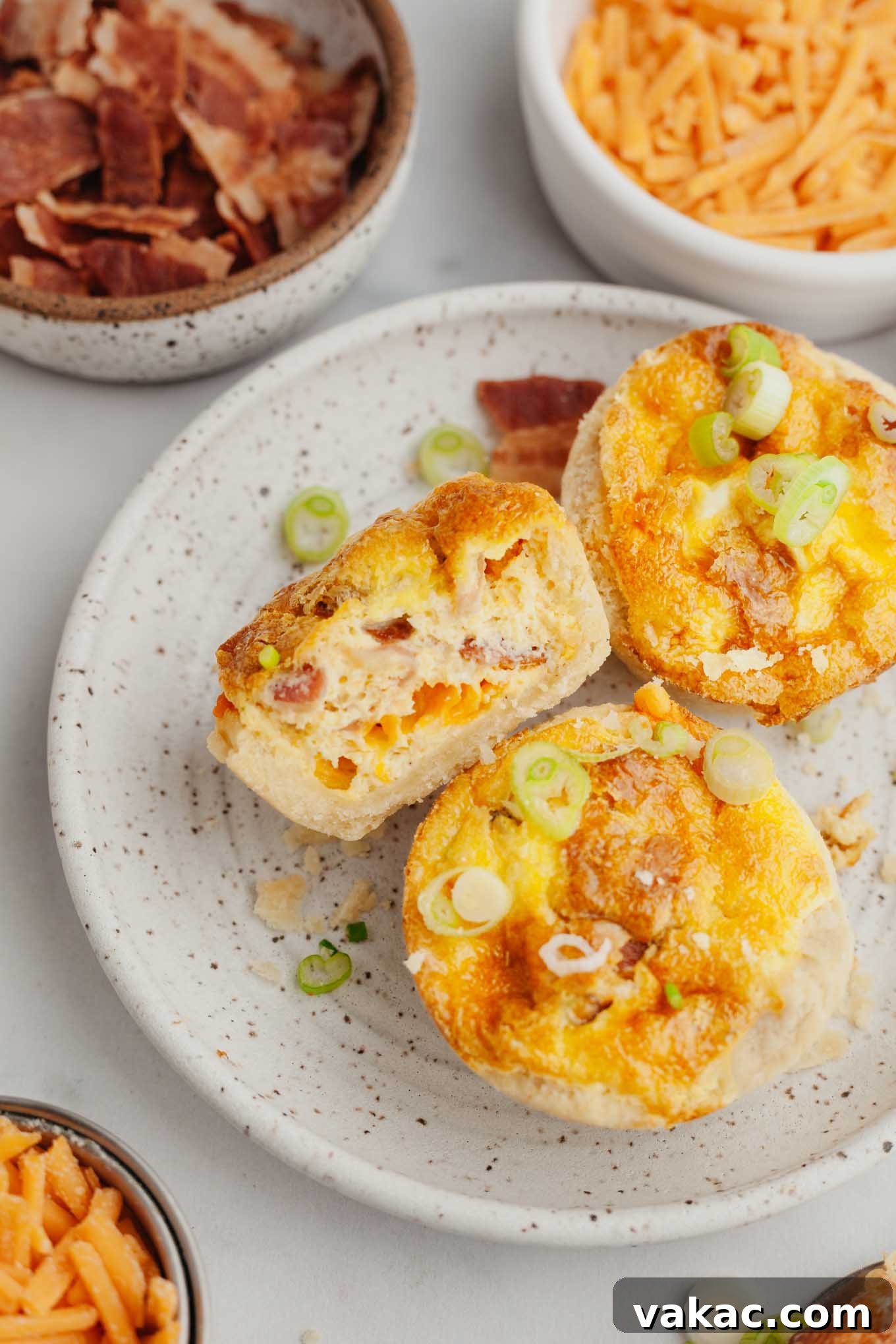 Bite-Sized Quiche Delights 10 An overhead view of beautifully baked mini quiches artfully arranged on a plate. One quiche is cut in half, revealing its savory interior.