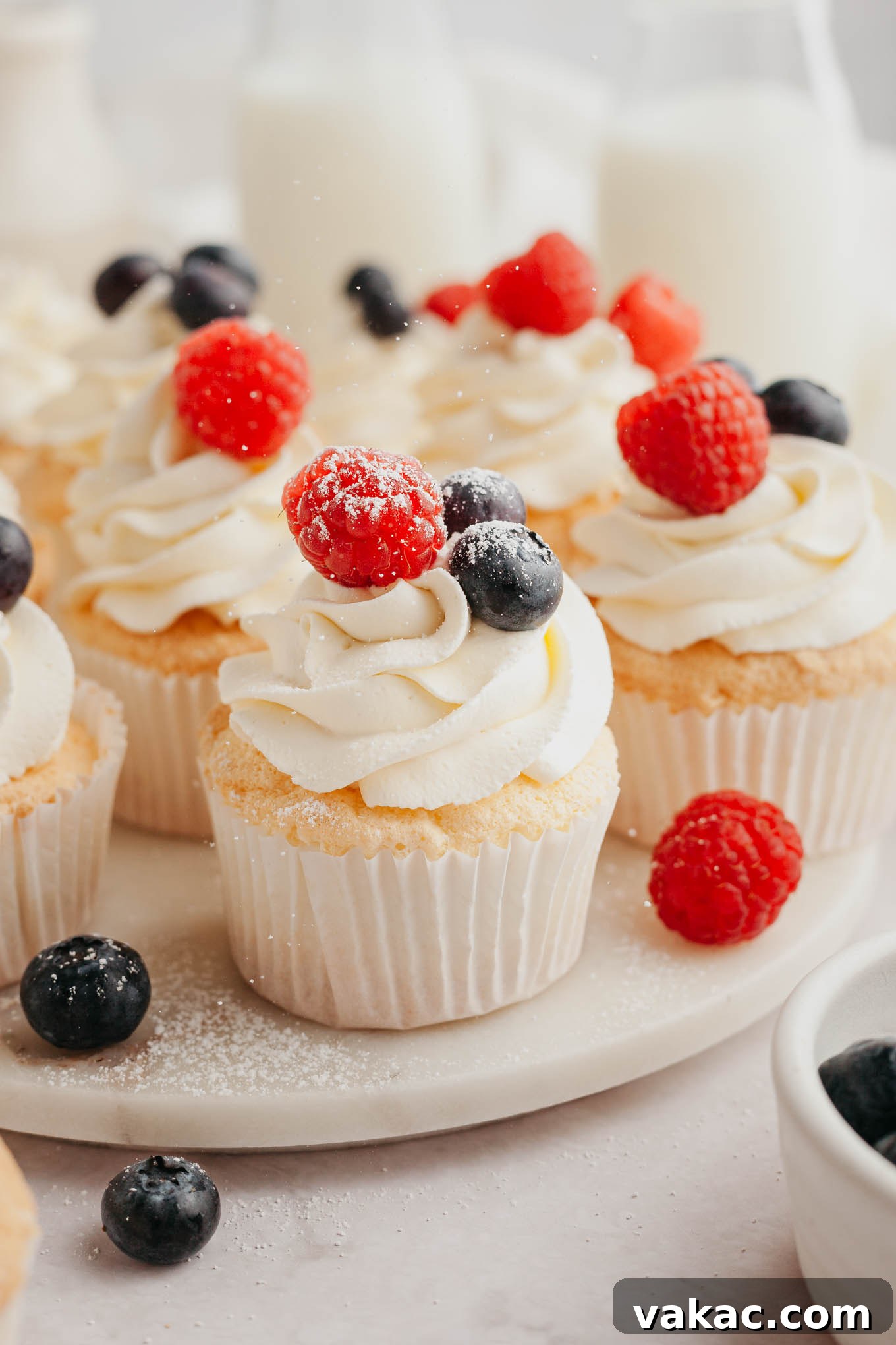 Cloud-Light Cupcakes 2 Angel food cupcakes topped with whipped cream on a serving plate.