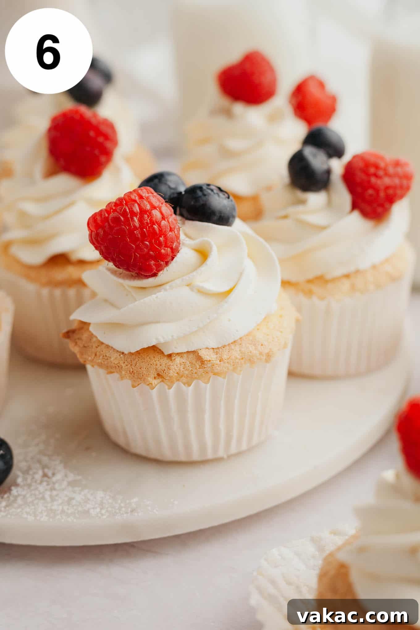 Cloud-Light Cupcakes 9 Several angel food cupcakes topped with whipped cream and fresh berries.