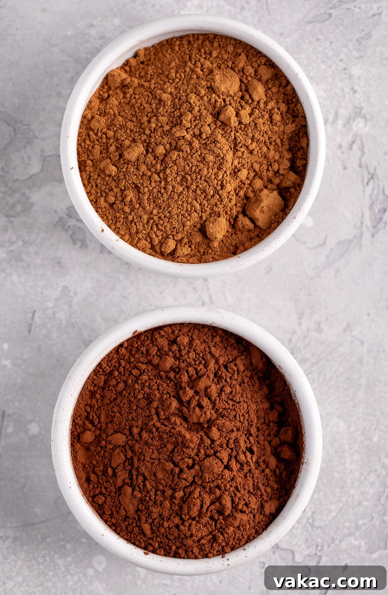 Natural vs. Dutch Process Cocoa: The Baker's Choice 7 An overhead shot showcasing two white bowls: one filled with natural cocoa powder and the other with darker Dutch process cocoa powder, highlighting their visual difference.